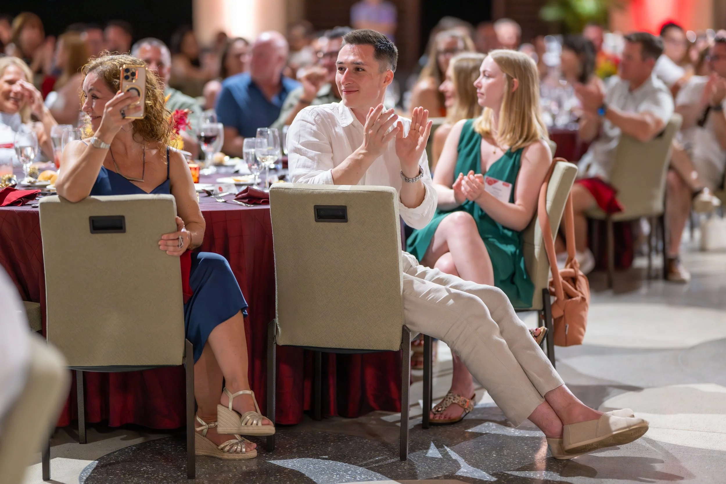 Guests applauding while seated at a corporate awards dinner.