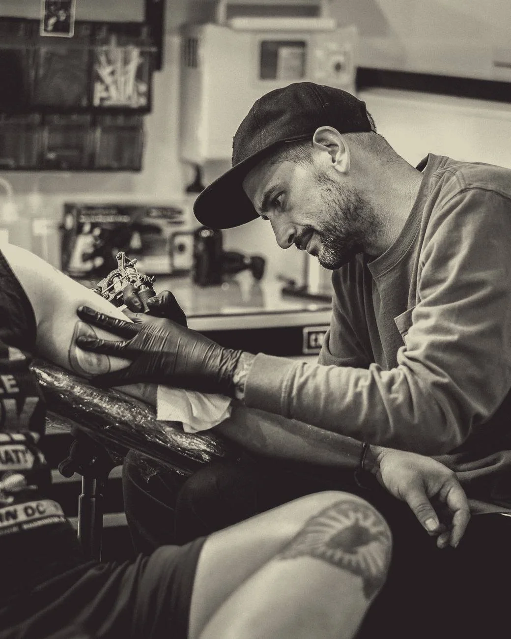 An artist at work on a client's leg