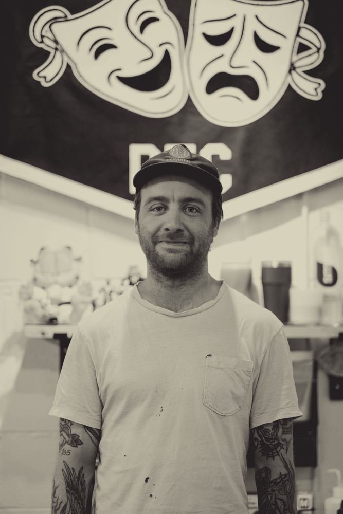 Tim Huck in front of his pennant at the shop
