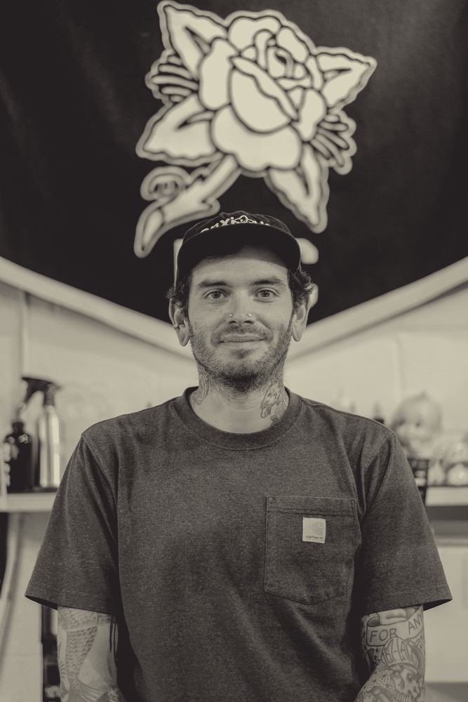 Drew Morgan in front of his pennant at the shop