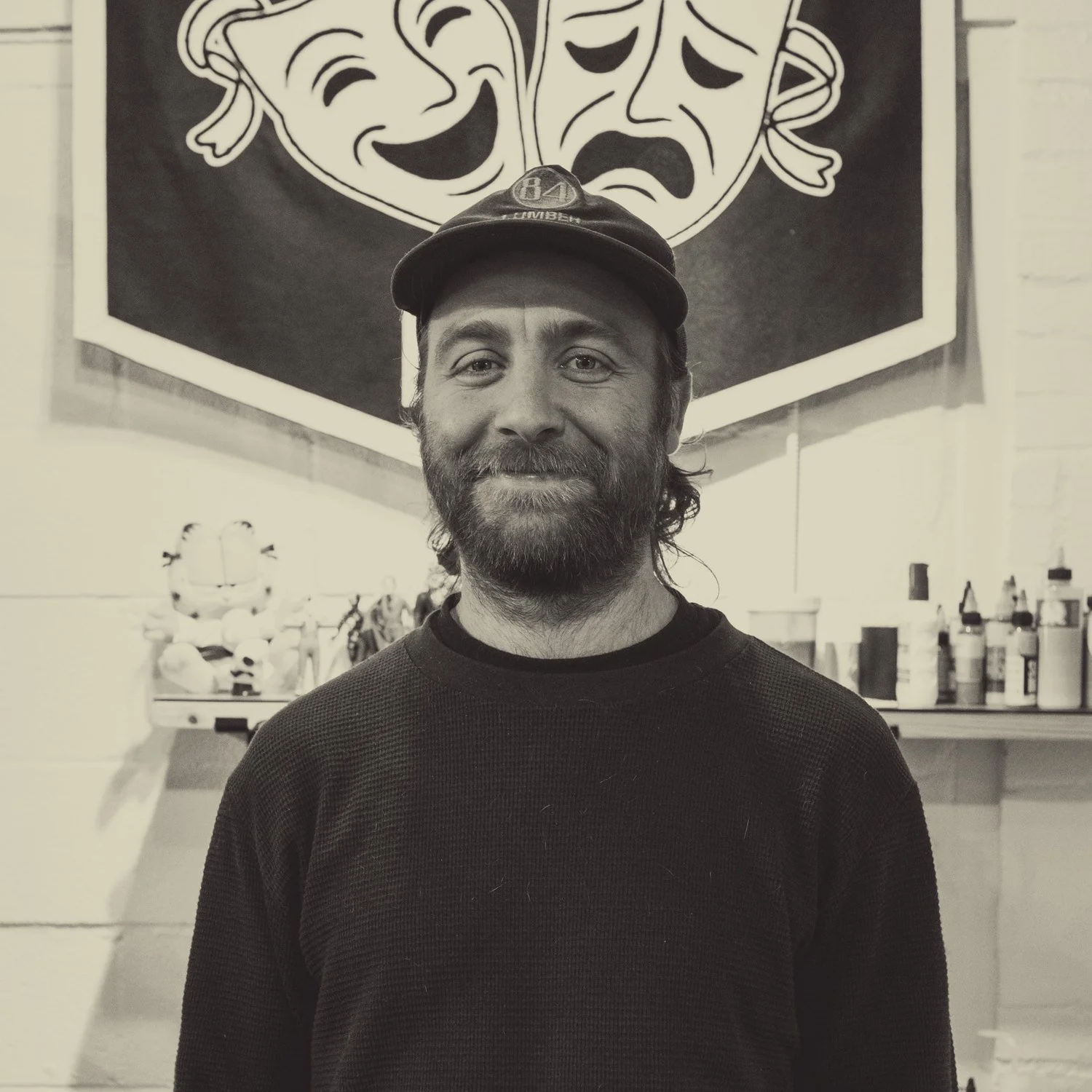 Tim Huck in front of his pennant at the shop