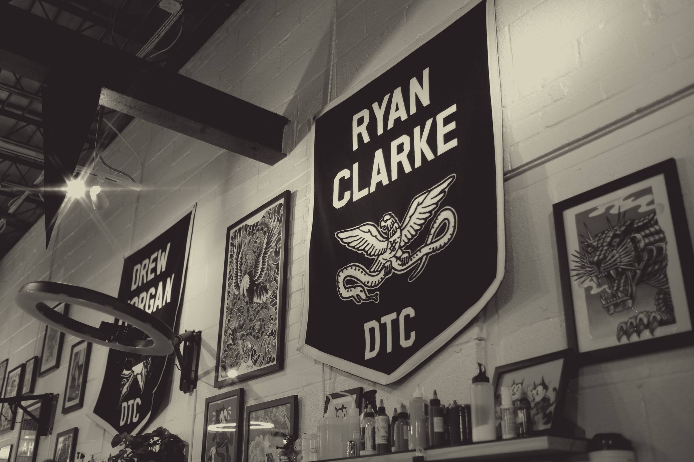 Ryan Clarke's and Drew Morgan's pennants on the shop wall, with framed flash and the station lights