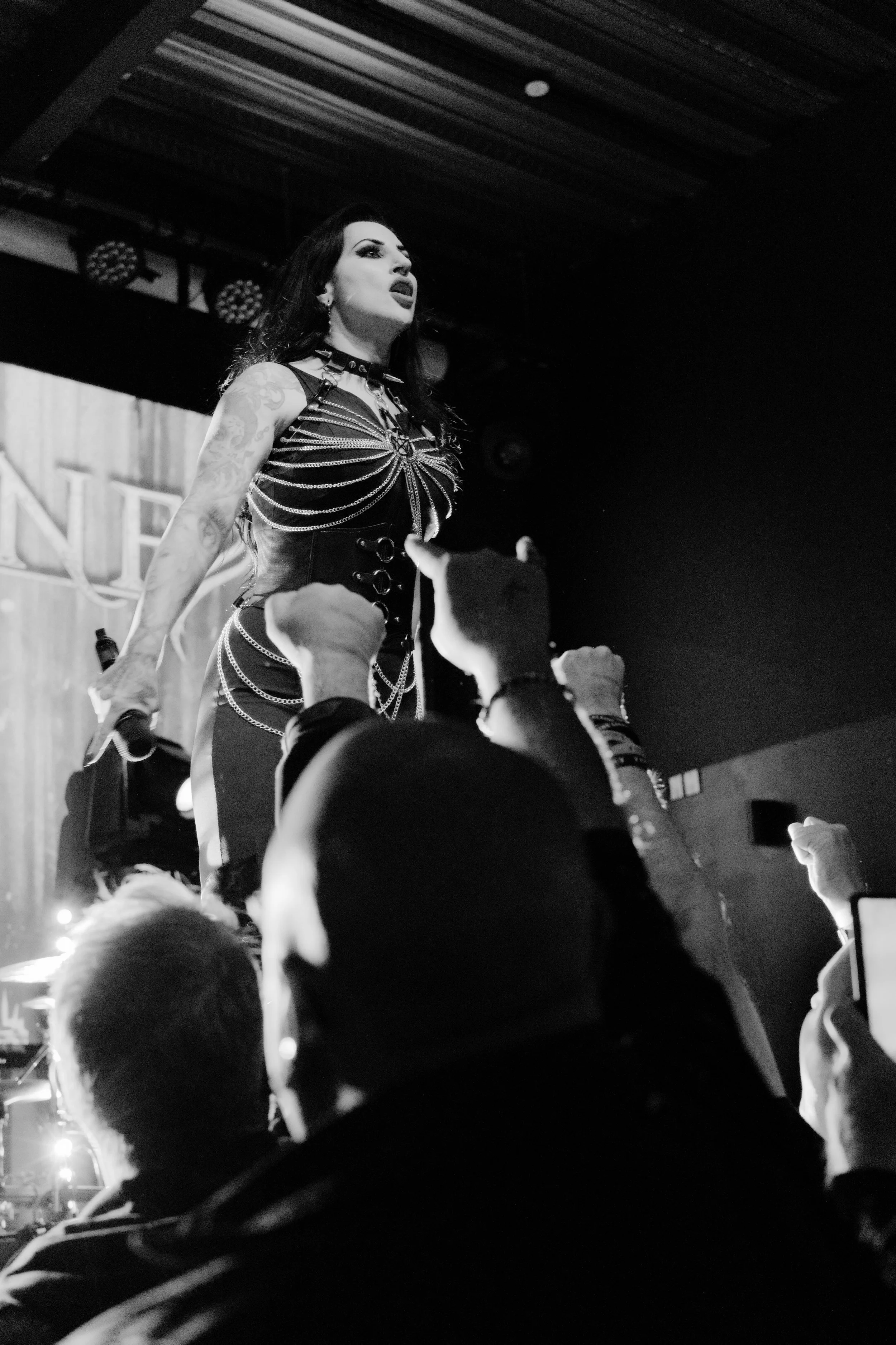 A singer of metal band at the stage in front of her fans