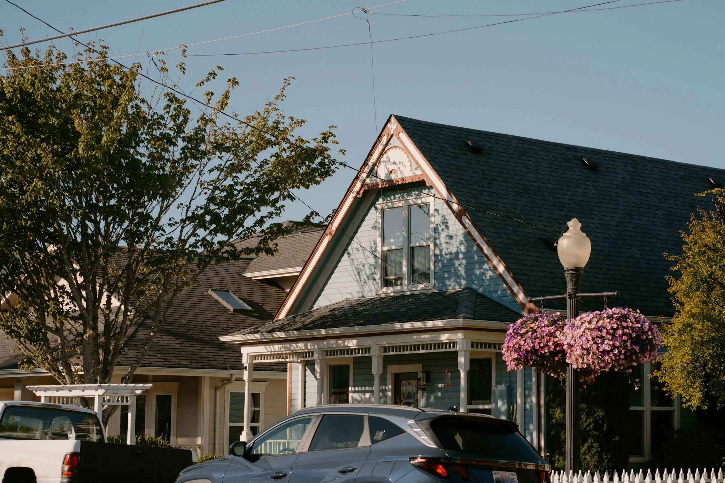 Blue Victorian-style home with a front porch and hanging flower baskets, Sunnyside neighborhood guide for Denver first-time home buyers