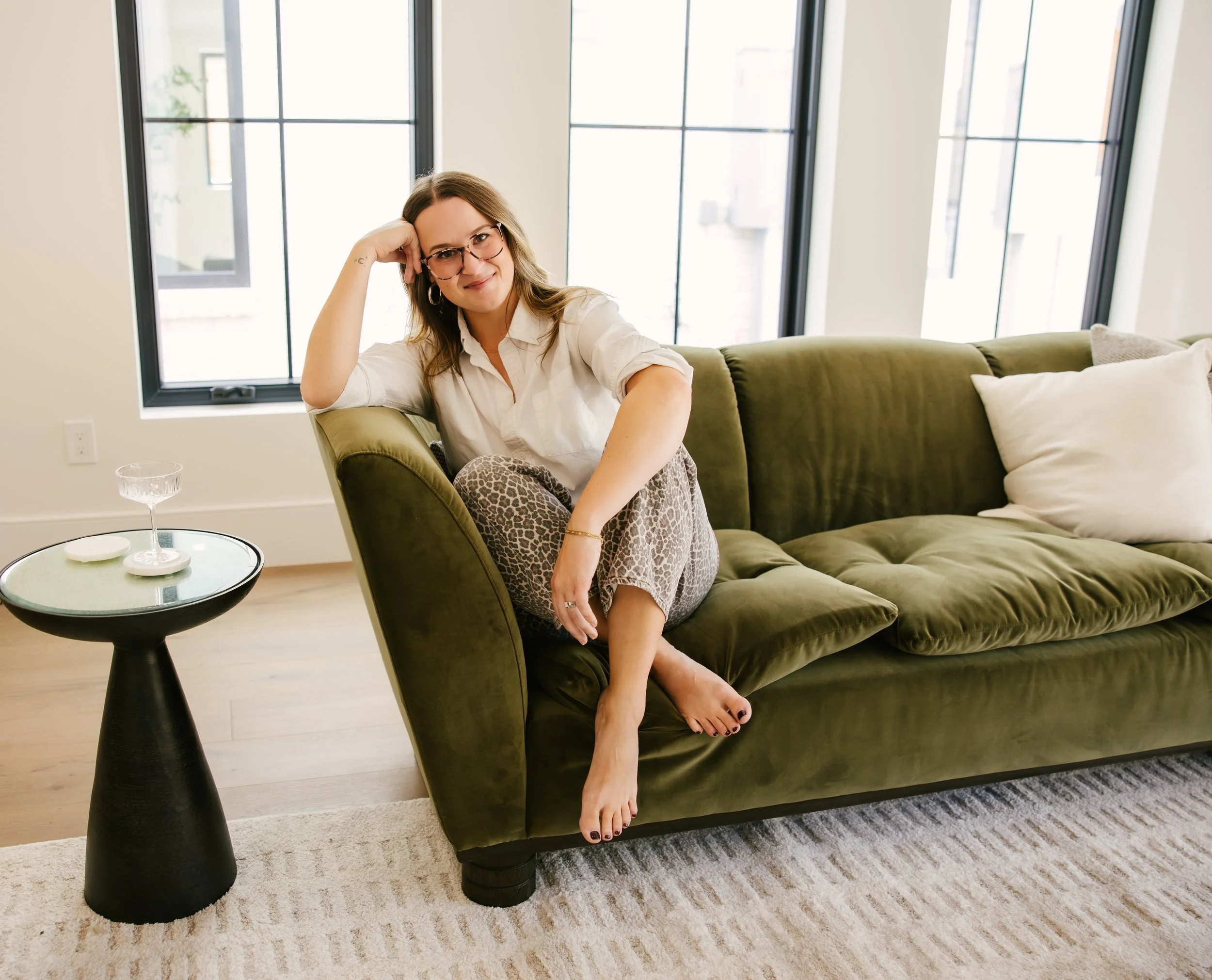 Kayla Vice, Denver real estate agent, relaxing on a green velvet sofa