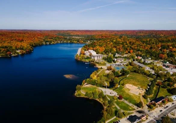 Aerial view of Haliburton village and Head Lake in Haliburton County, Ontario, surrounded by colourful autumn forests and waterfront homes.