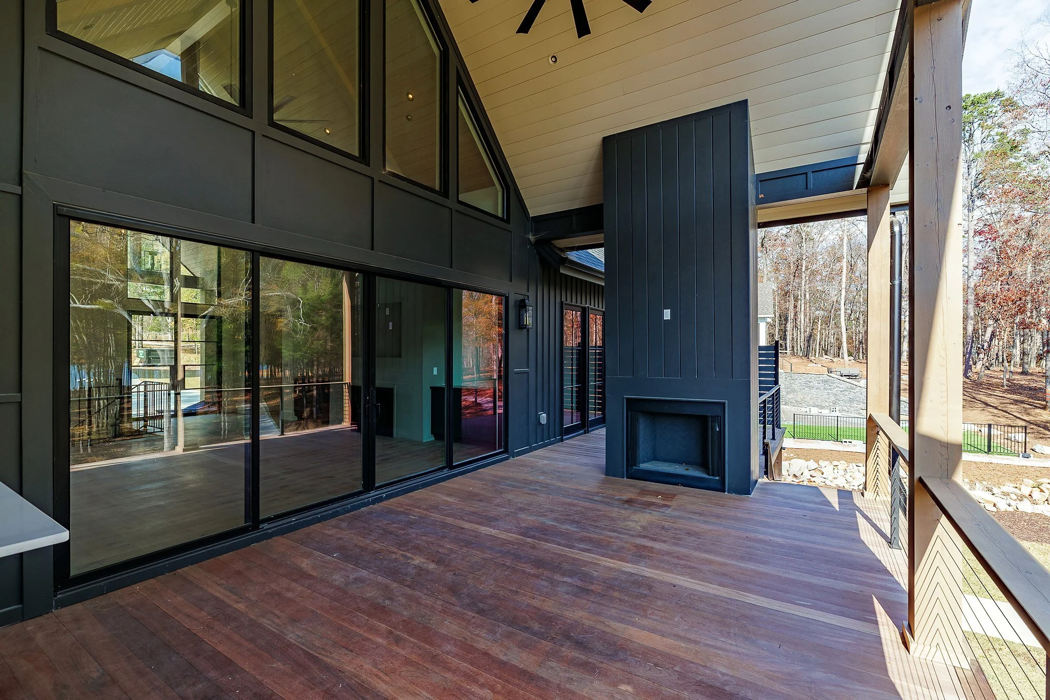 Covered porch with outdoor fireplace and wooded views