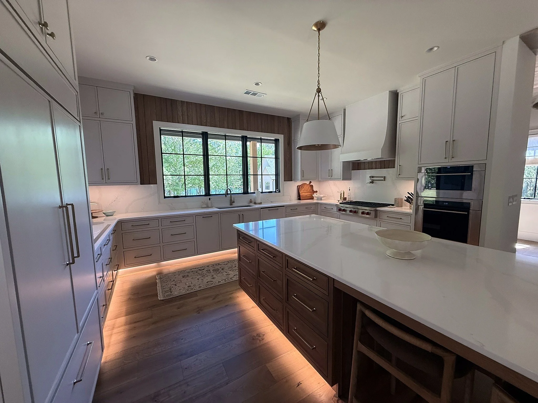 Kitchen island with toe-kick lighting and custom cabinetry