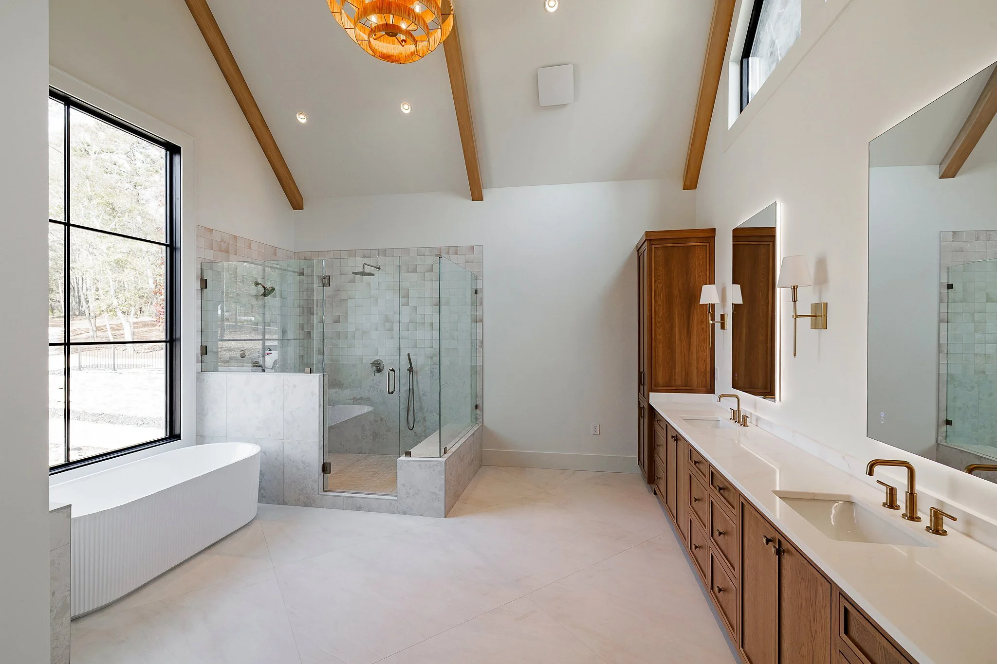 Primary bath with freestanding tub, glass walk-in shower, and vaulted ceiling