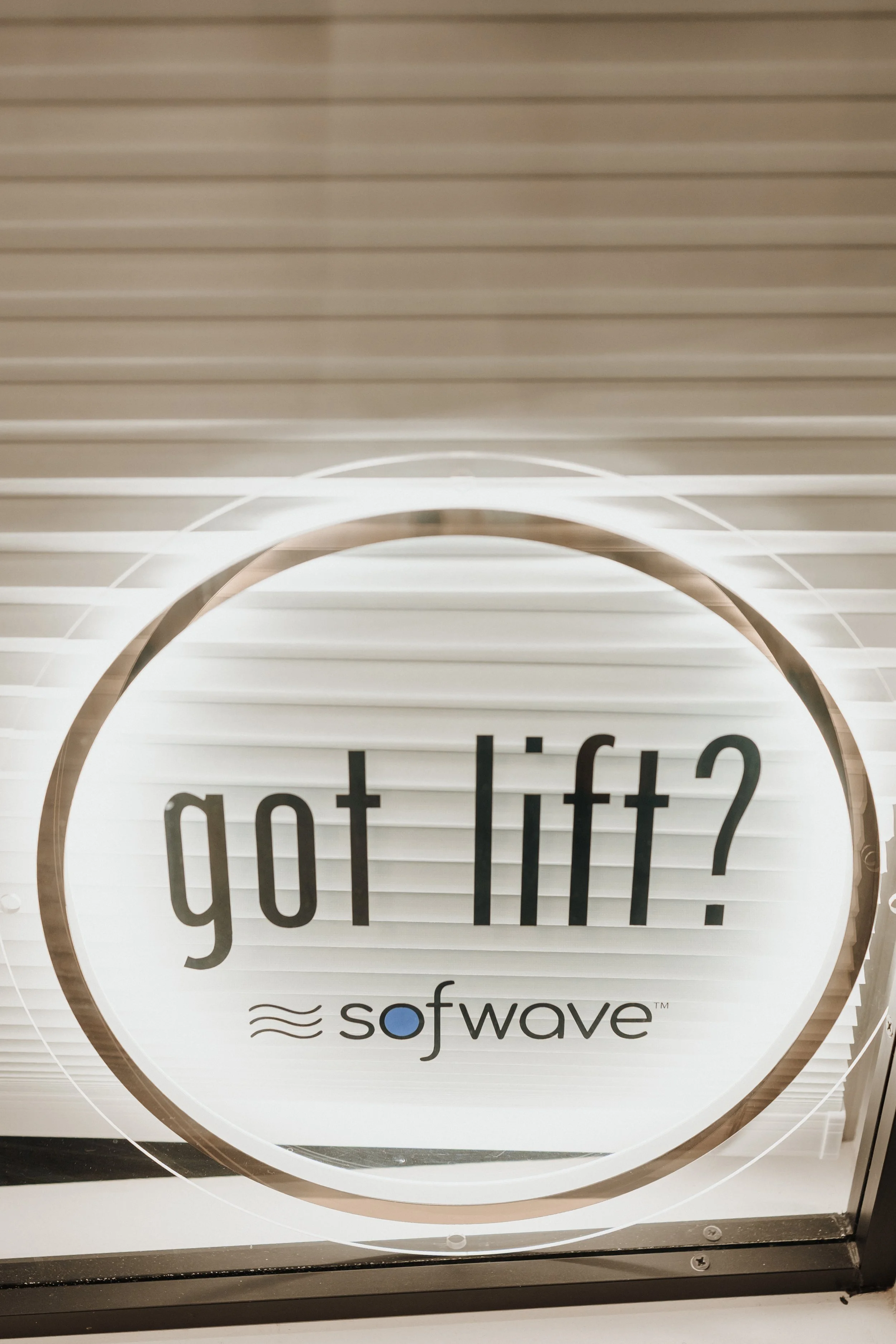 Close-up of a round window sign reading “go the lift?” with the Sofwave logo.
