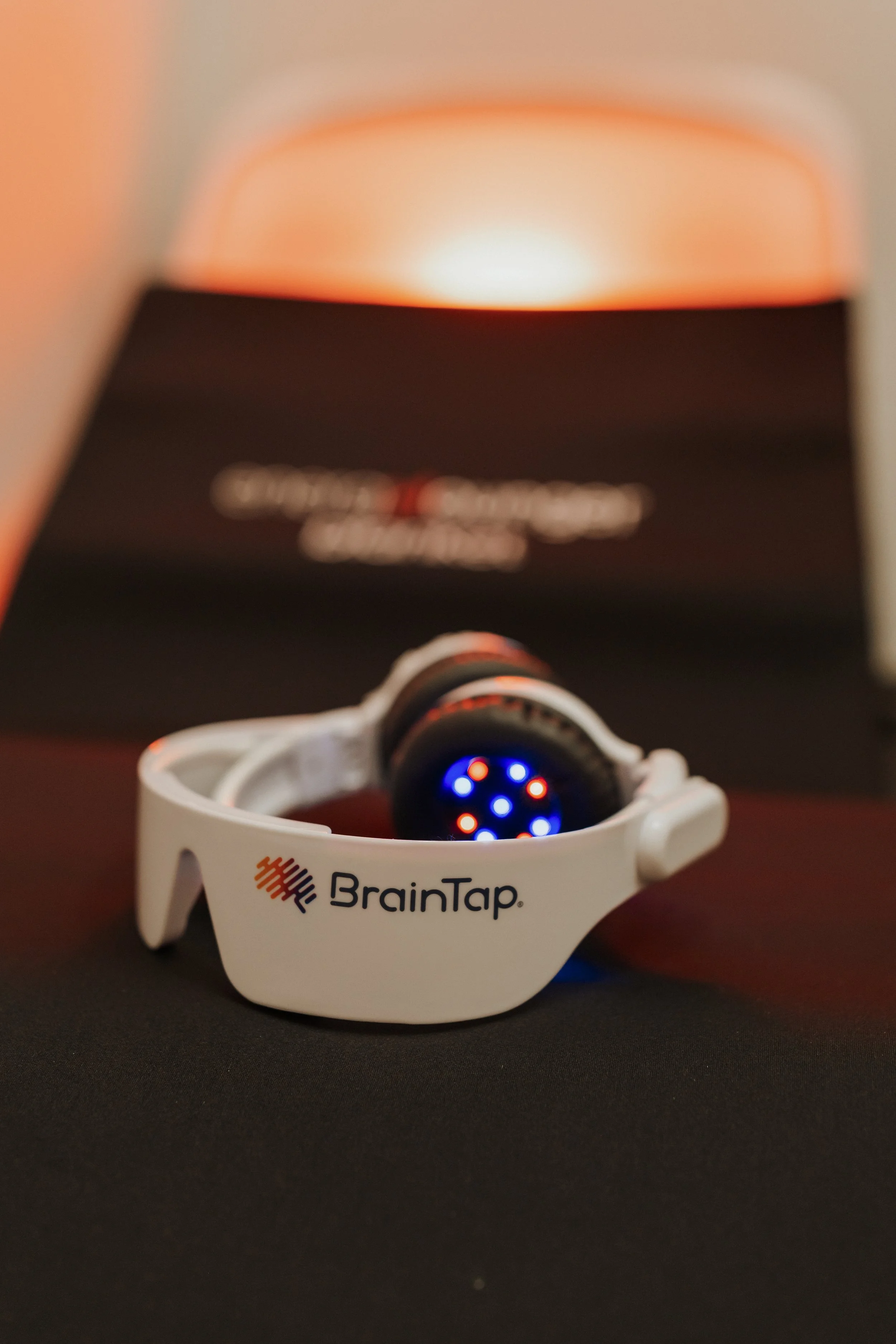 BrainTap neurofeedback headset with glowing sensors resting on a dark surface