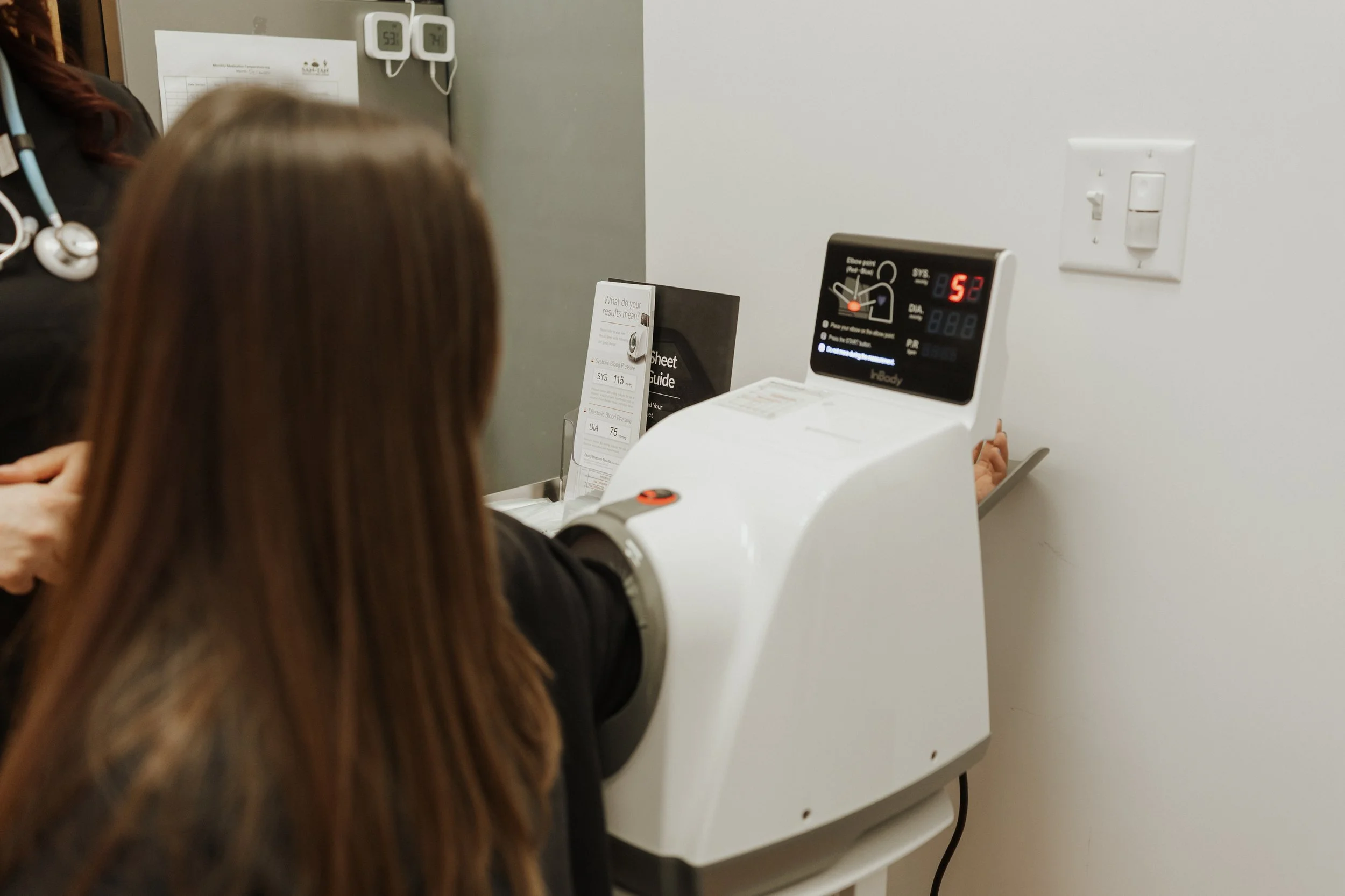 Patient undergoing an automated blood pressure test in a medical office