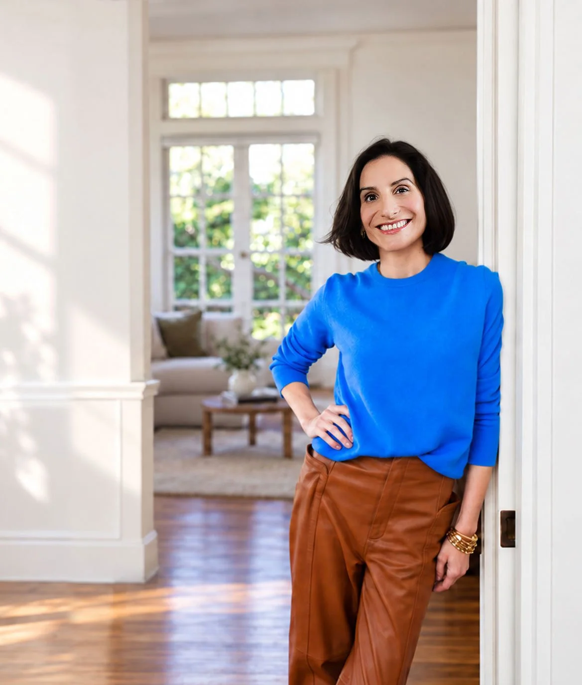 Whitney Light, CDFA, Certified Divorce Financial Analyst and Divorce Financial Strategist | Smiling woman in a bright blue sweater and brown leather pants standing in a sunlit home doorway