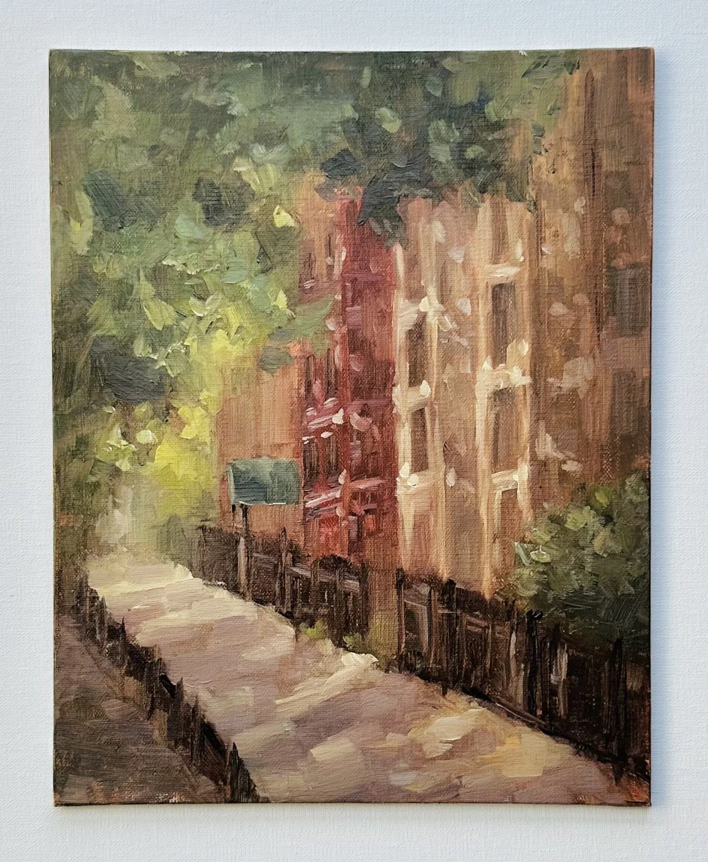 Impressionist painting of a tree-lined path leading toward colorful red and orange buildings.