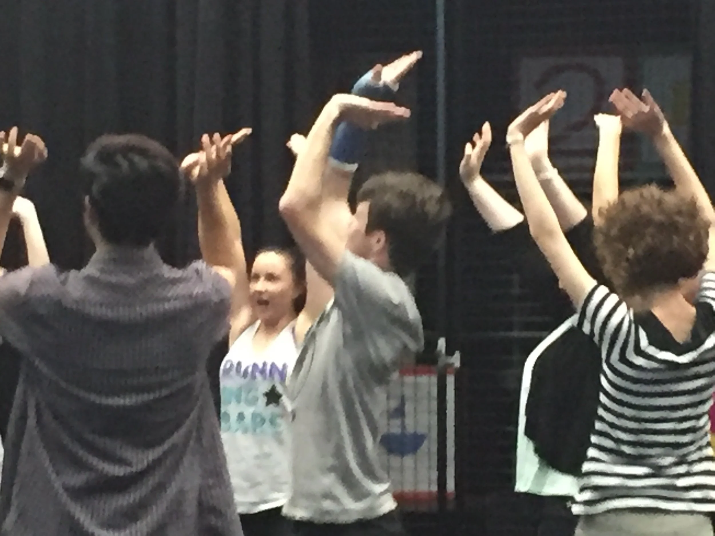 Audience members raising their hands during an indoor event