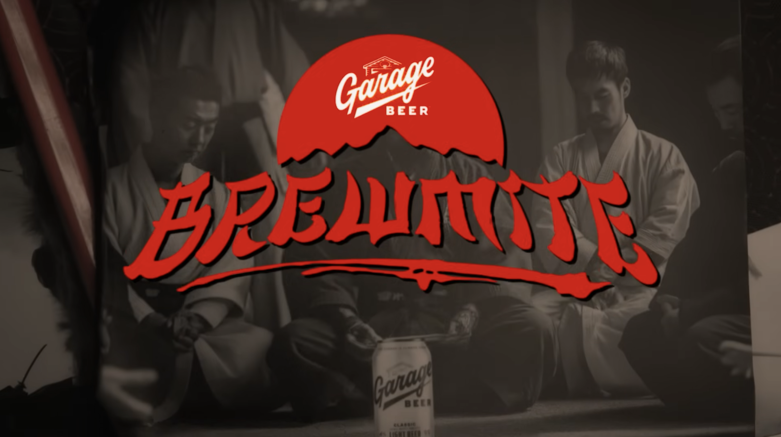 A black-and-white image of people wearing martial arts uniforms sitting around a table with a red circular logo in the center that reads 'Garage Beer' with a mountain graphic and stylized text below.