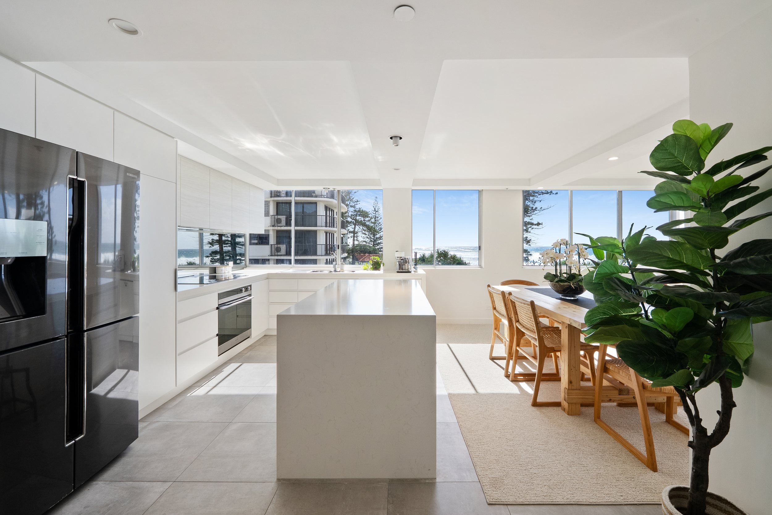 Kitchen with stainless steel fridge and dining table