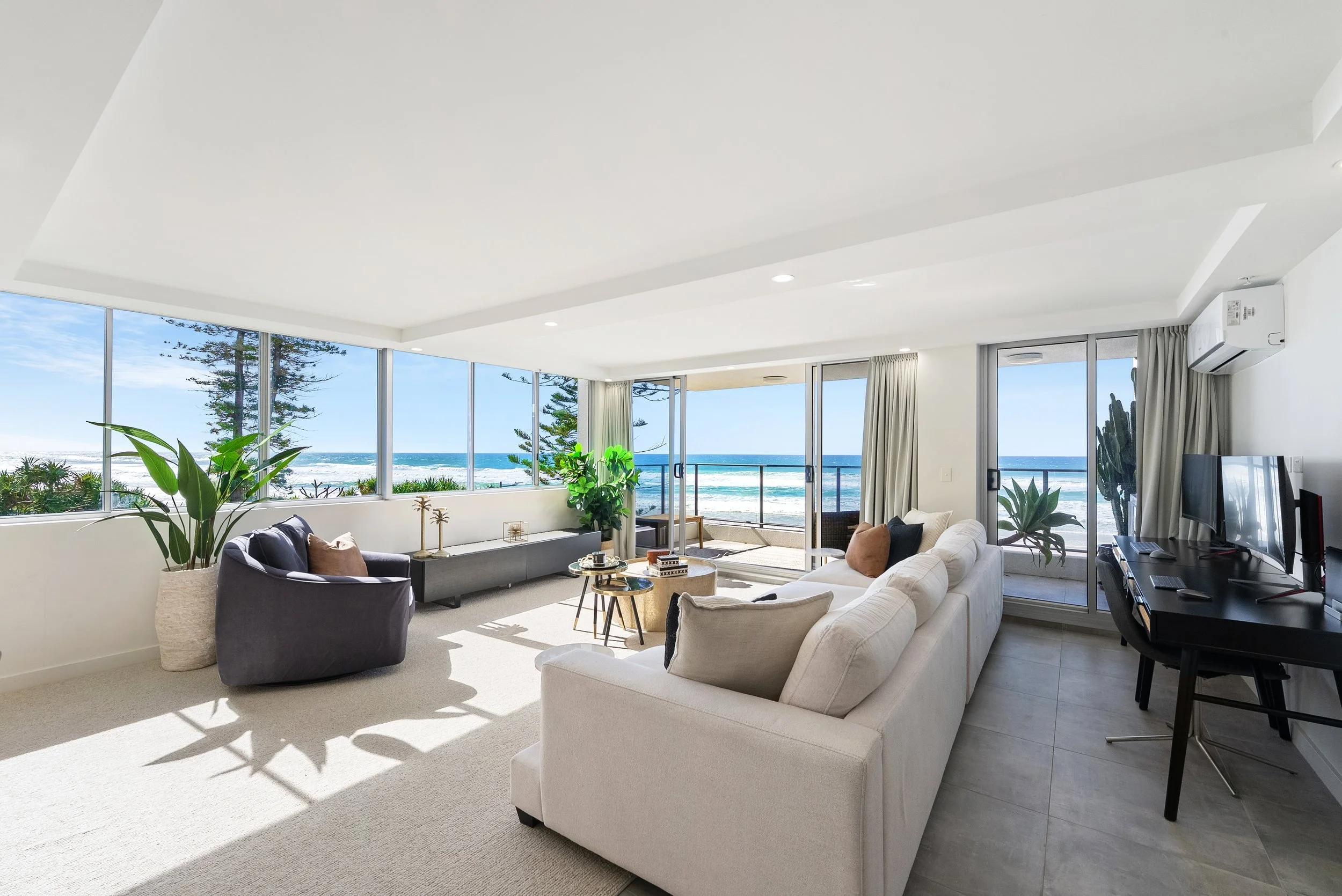 Open-plan lounge with ocean views through glass doors