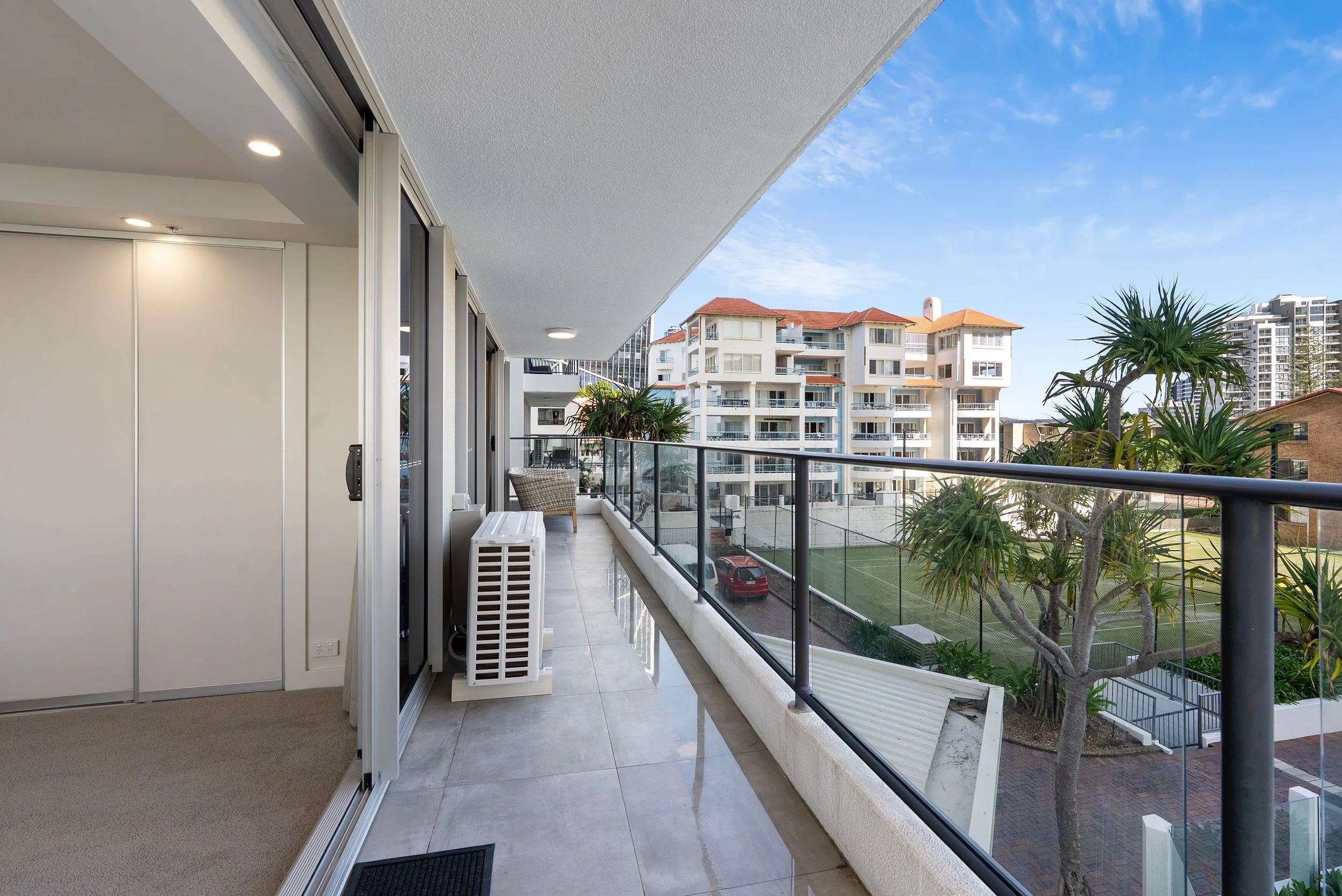 Covered rear balcony overlooking the pool and tennis court