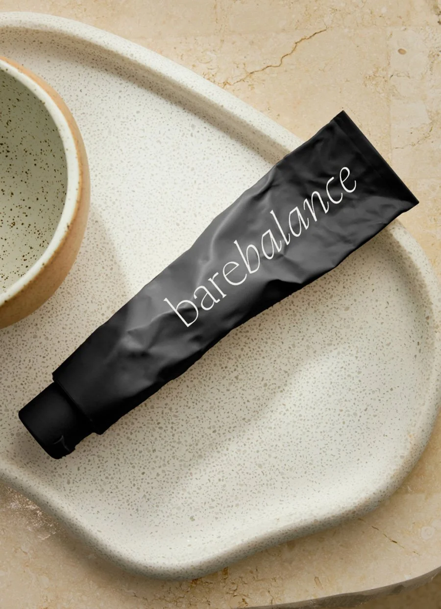 Black Balance tube on a speckled ceramic plate beside a matching cup