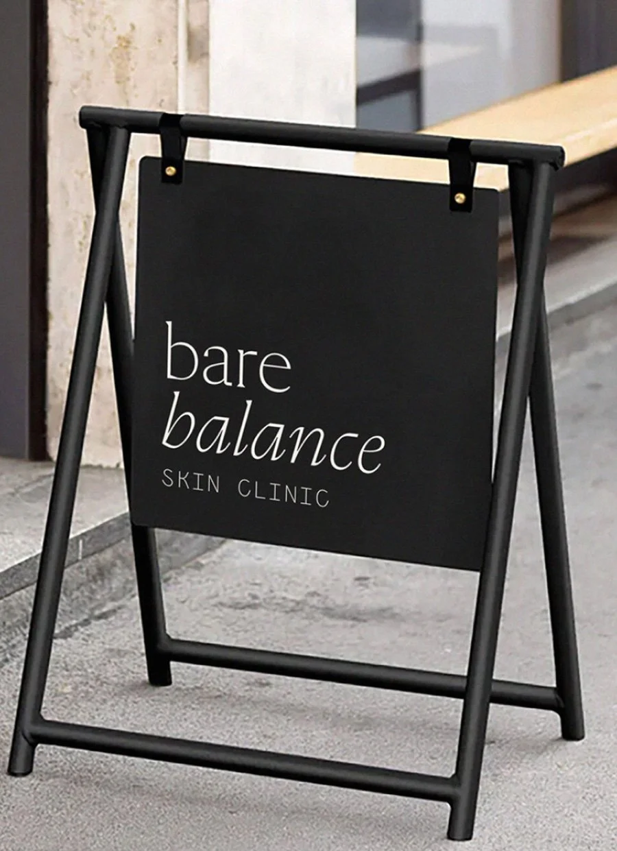 Black sidewalk A-frame sign advertising Bare Balance Skin Clinic