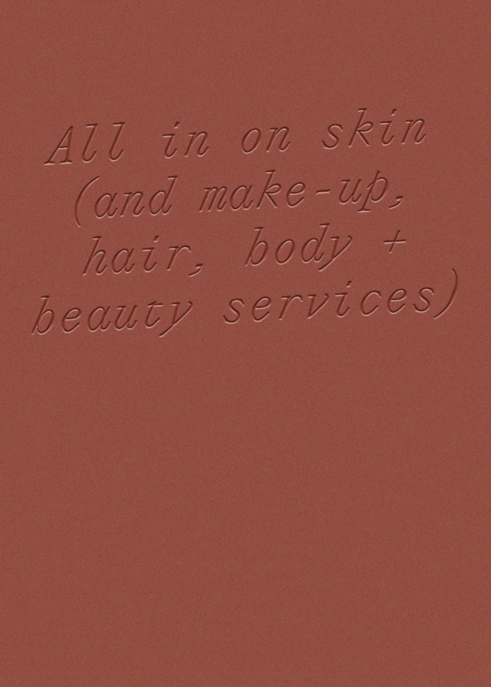 Close-up of embossed text reading “All in one skin and make-up, hair, body + beauty services” on a terracotta background.