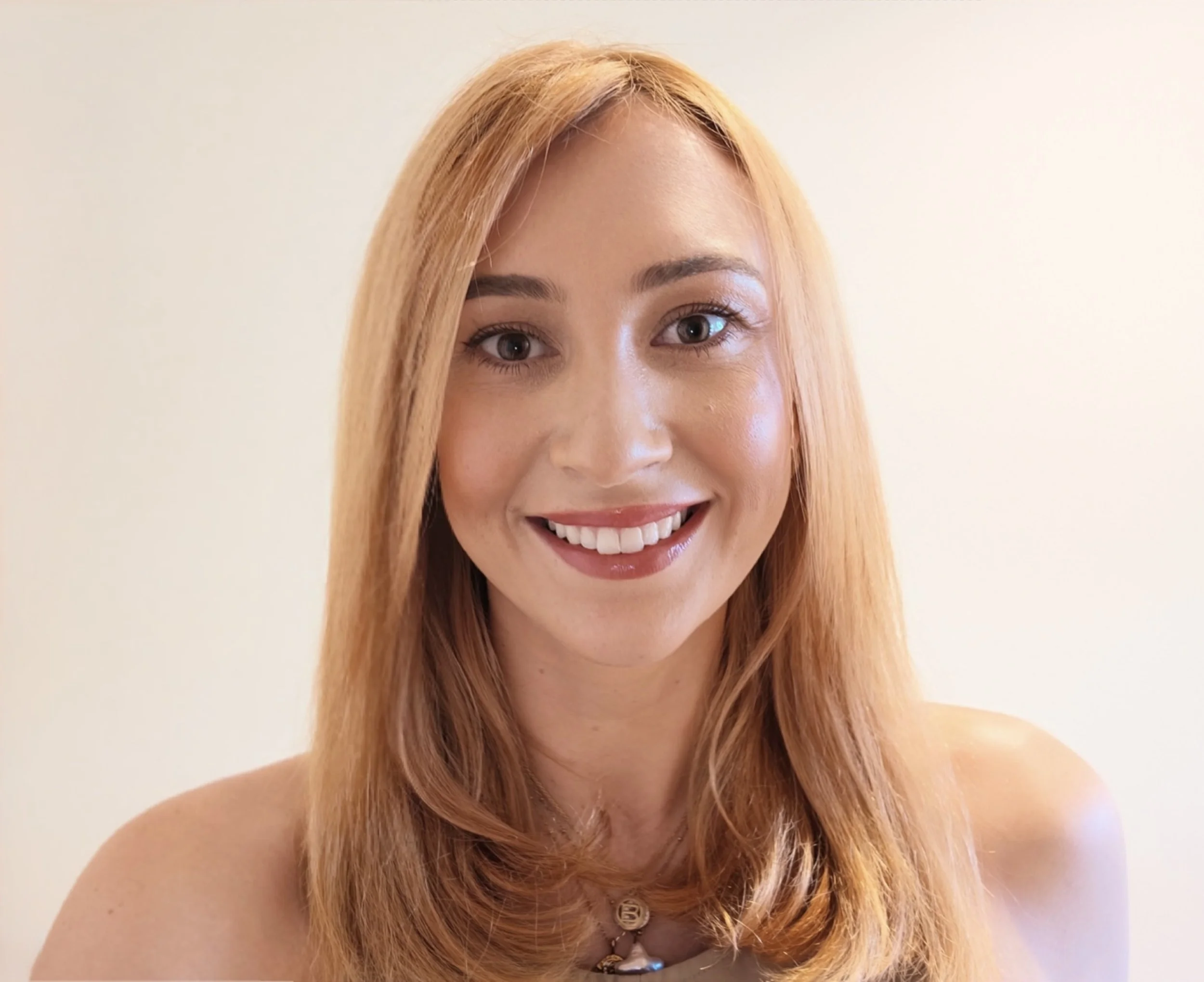 Smiling blonde woman with long hair posing in a close-up portrait