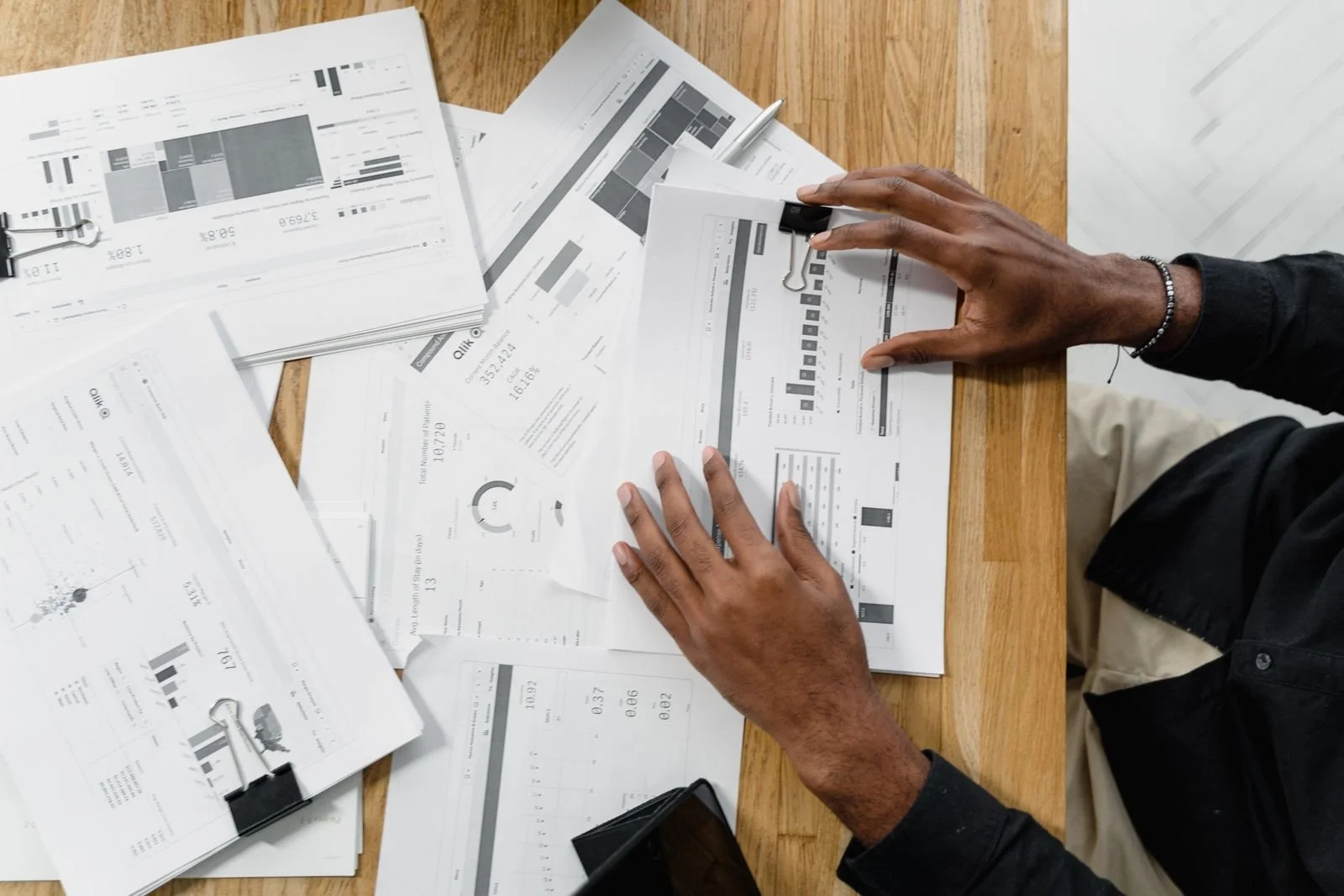 Hands reviewing printed financial reports on a desk