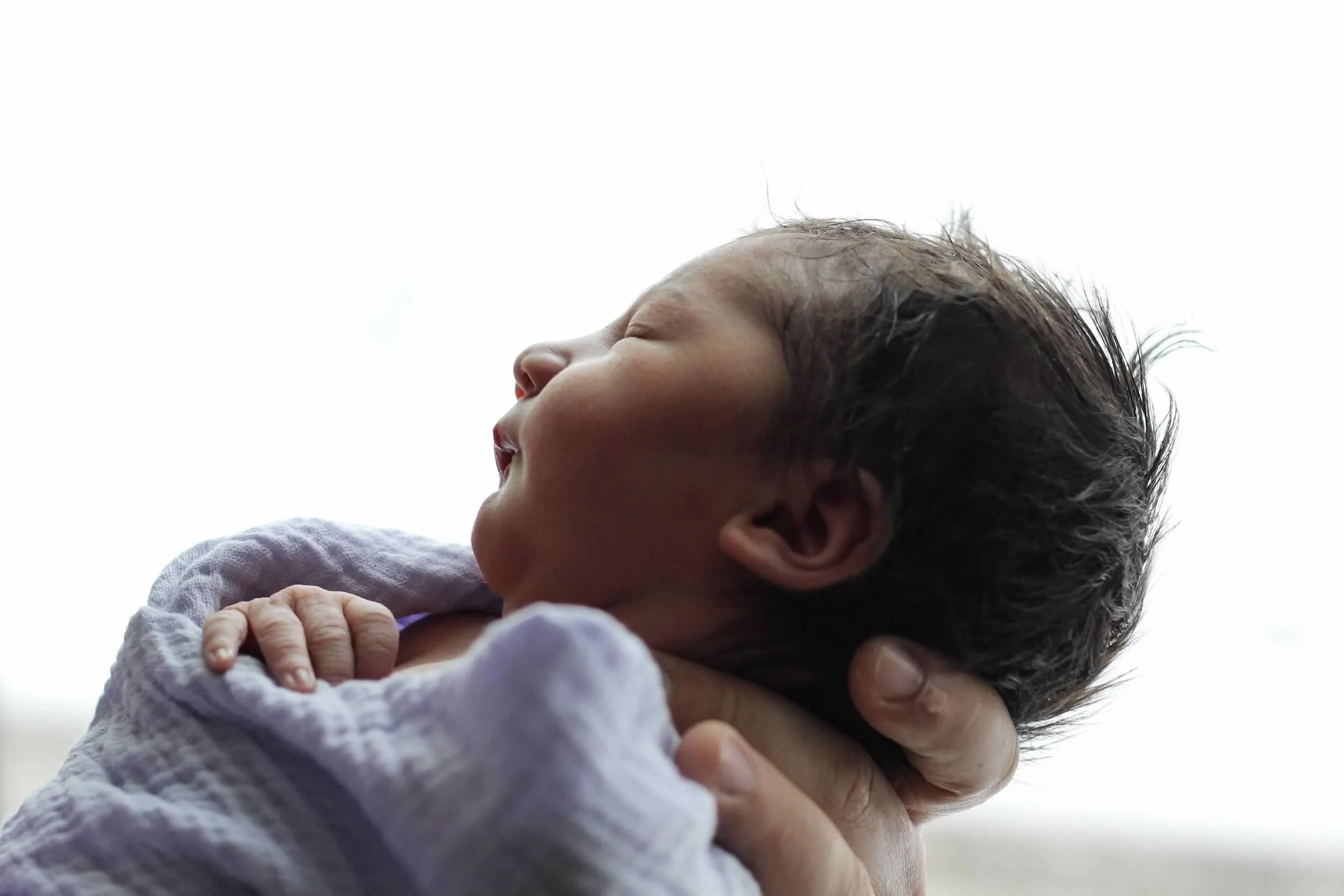 Close-up of a newborn baby  being by an adult