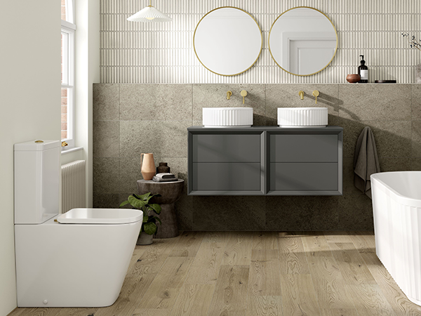 Modern bathroom with a freestanding bathtub, wall-mounted double vanity, round mirrors, and wood flooring