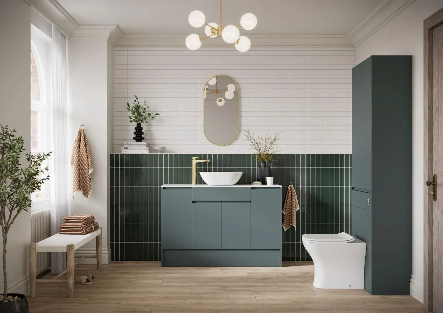 Modern bathroom with dark green subway tile, blue-gray vanity, vessel sink, arched mirror, freestanding toilet, and gold globe chandelier