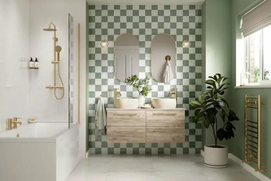 Modern green-and-white checkerboard bathroom with freestanding bathtub, wall-mounted double vanity, gold fixtures, arched mirrors, and potted plant