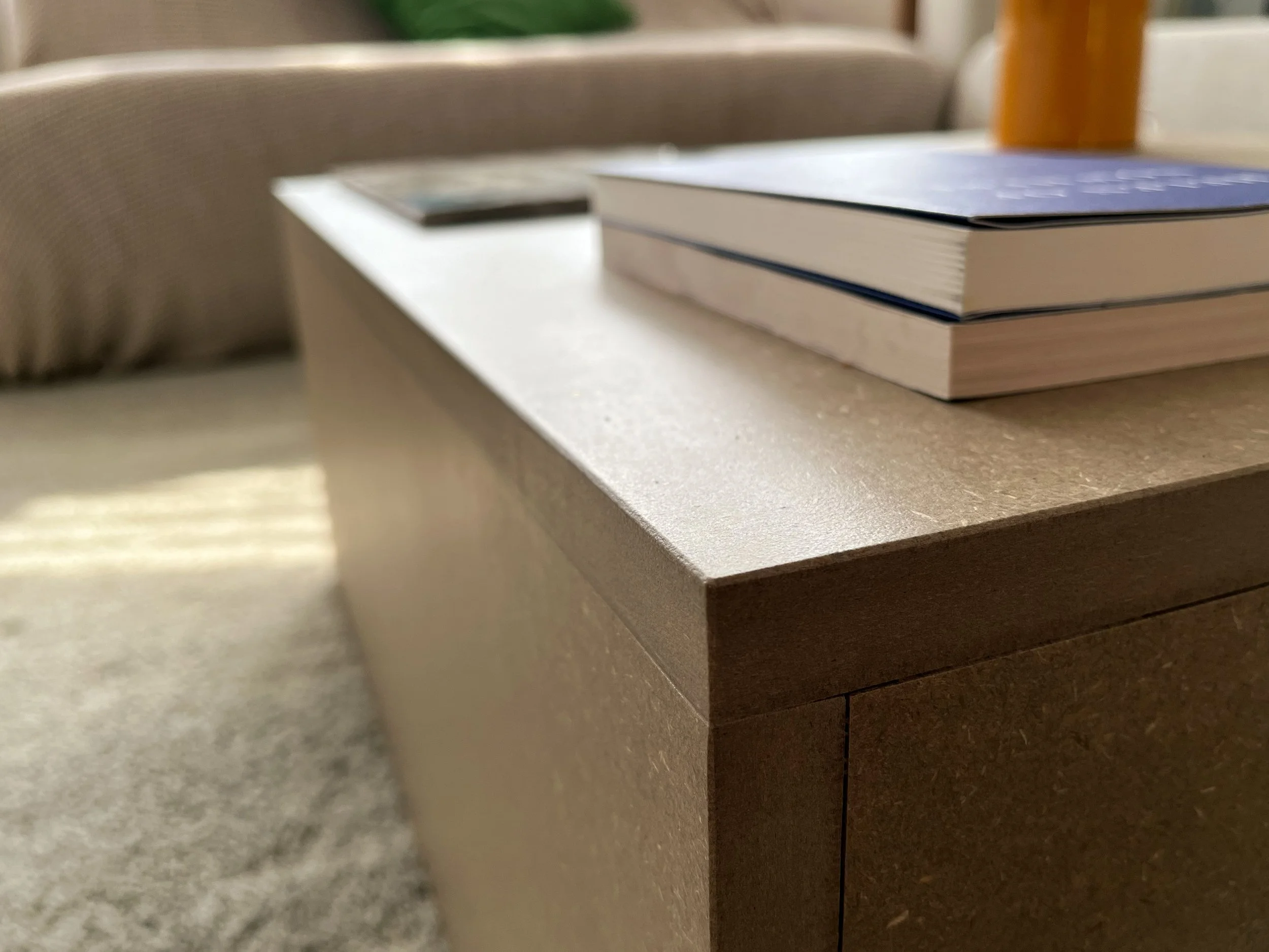 Close-up of coffee table with objects in the blurred background.