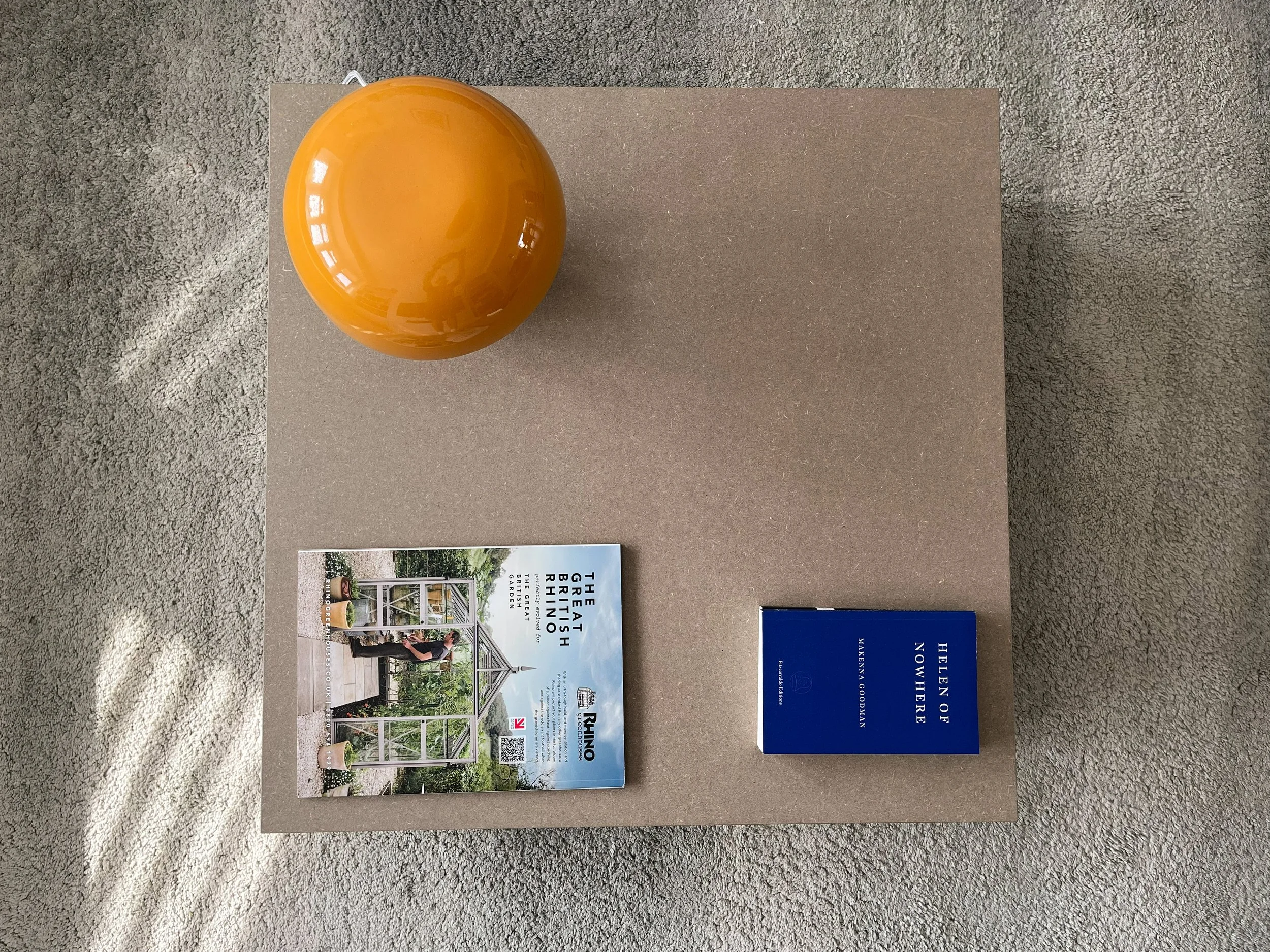 A coffee table with a light and books on top