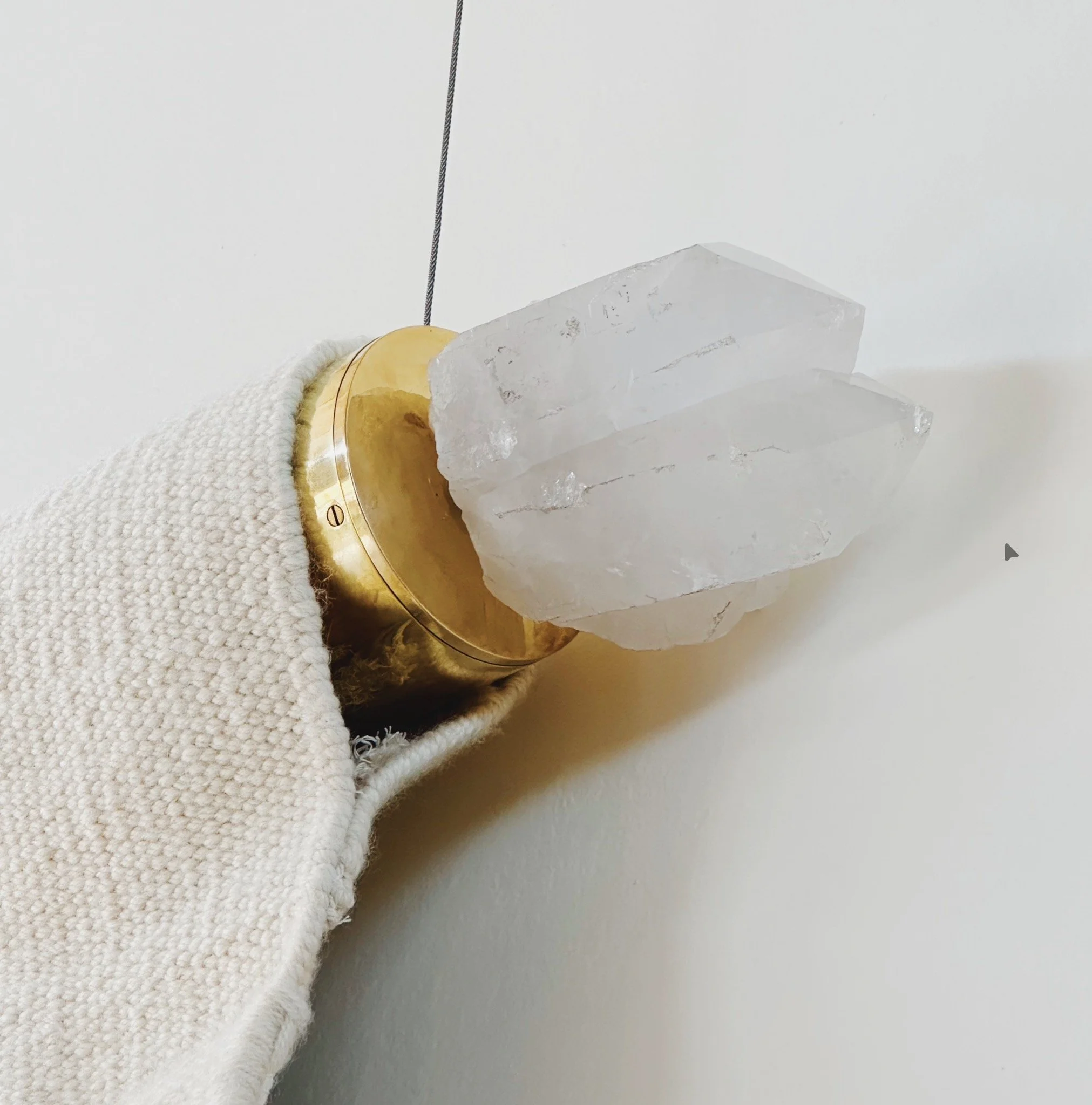 Main d'une personne portant un gant blanc tenant une pièce de roche gelée avec un anneau en métal doré autour.