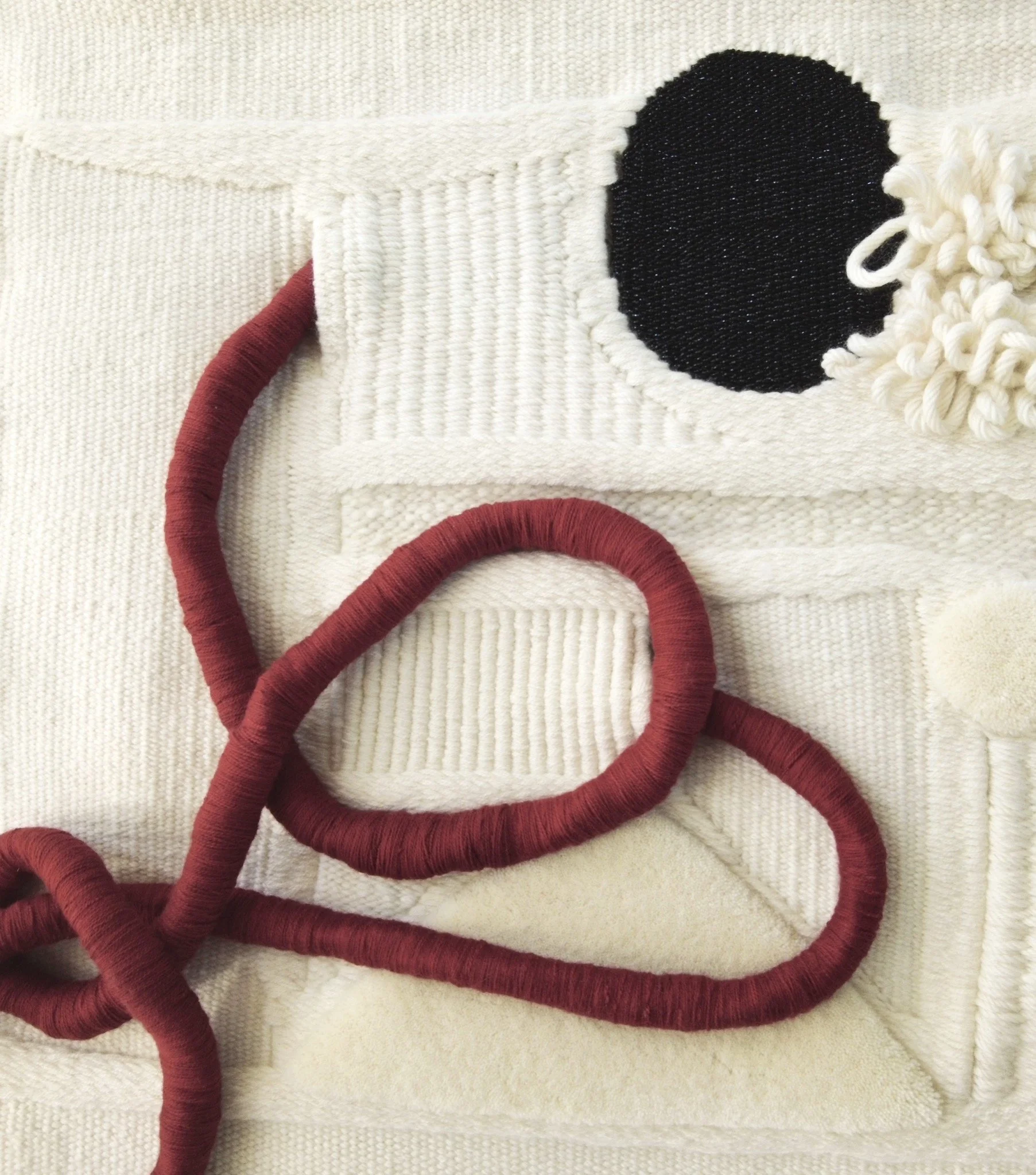 Une œuvre artistique en tissu représentant une icône de LinkedIn, avec un fond beige, le logo en noir et une petite décoration blanche autour.