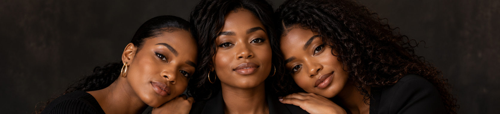Trois femmes noires avec des cheveux bouclés en pose proche sur fond sombre