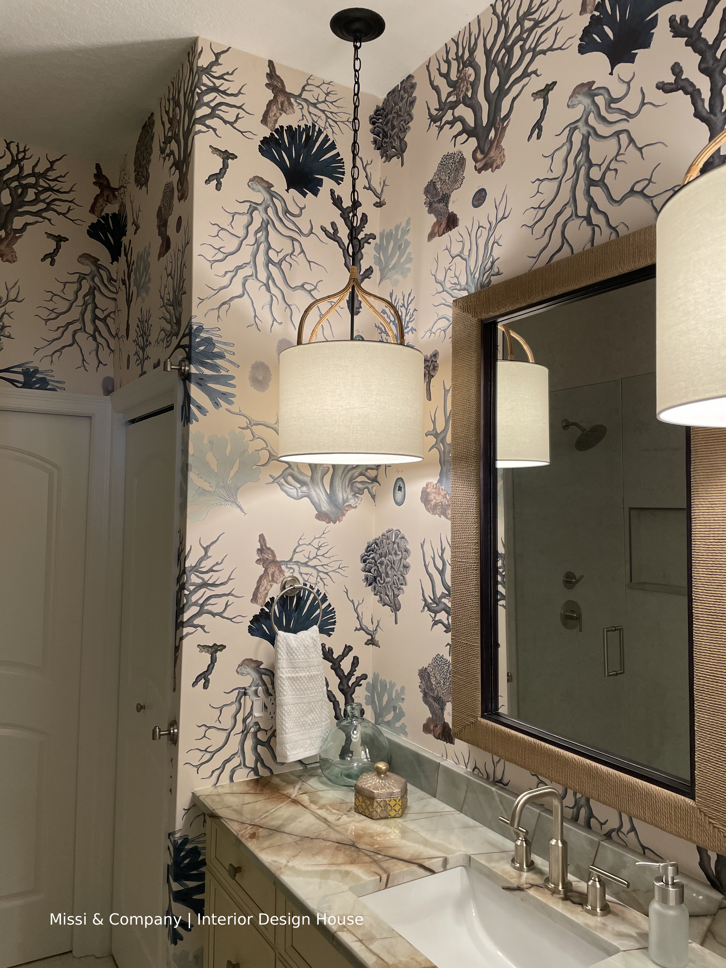 Bathroom with coral-inspired botanical wallpaper, marble countertop, vessel sink, and woven pendant light.