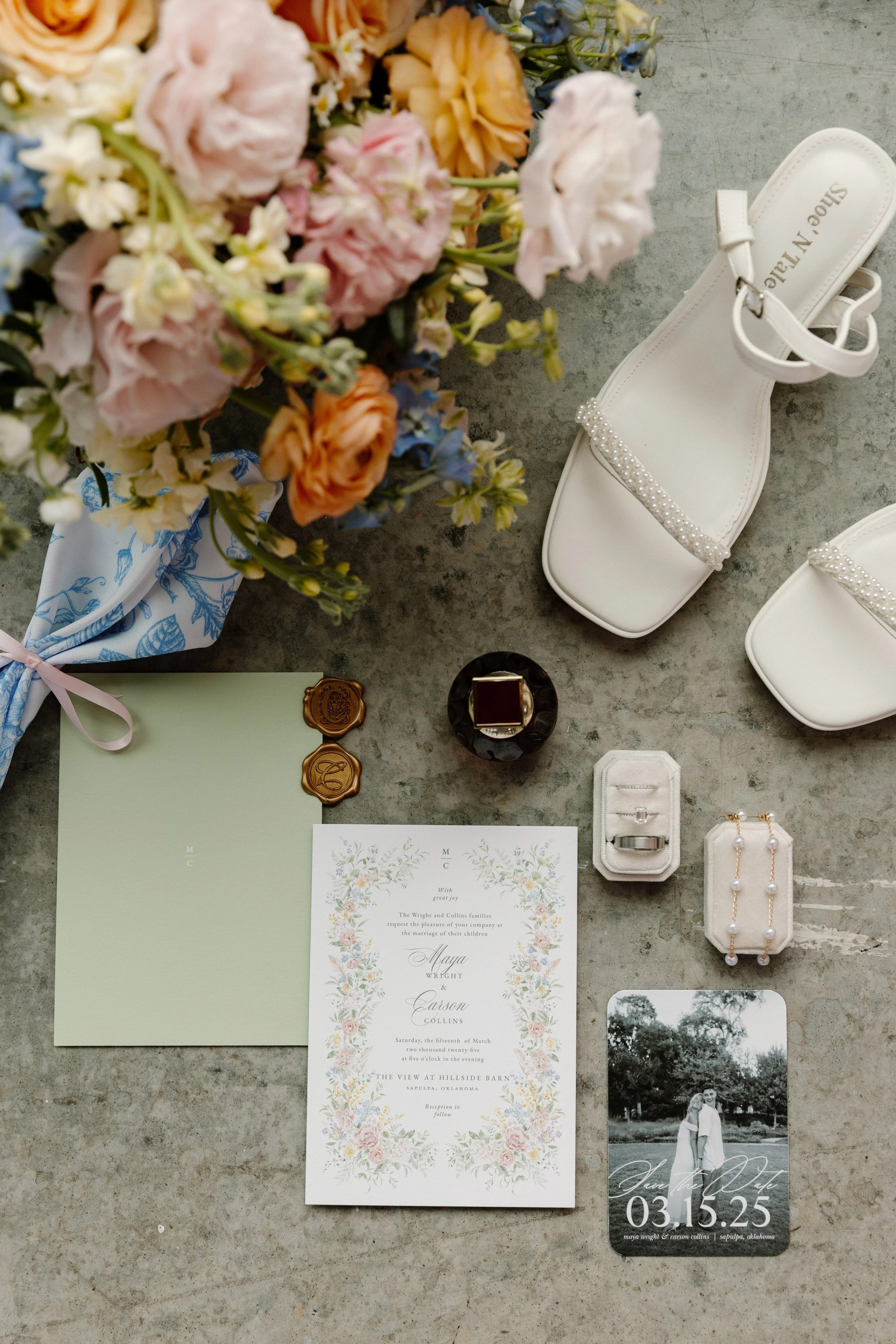 Wedding invitation, wedding photo, floral arrangements, white high-heeled shoes with pearl embellishments, jewelry, small decorative items.