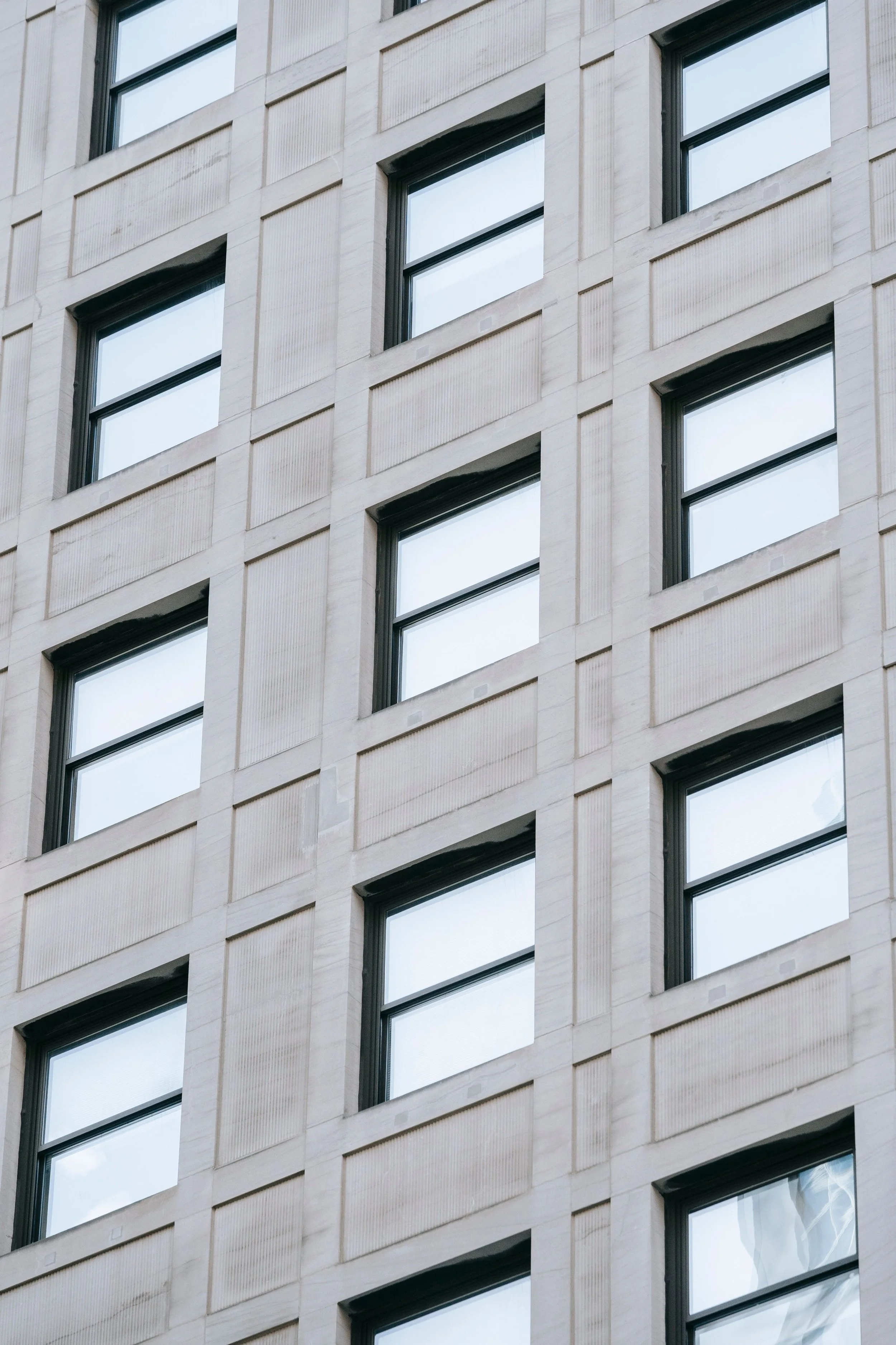 Light and shadow across the carefully structured facade of a building