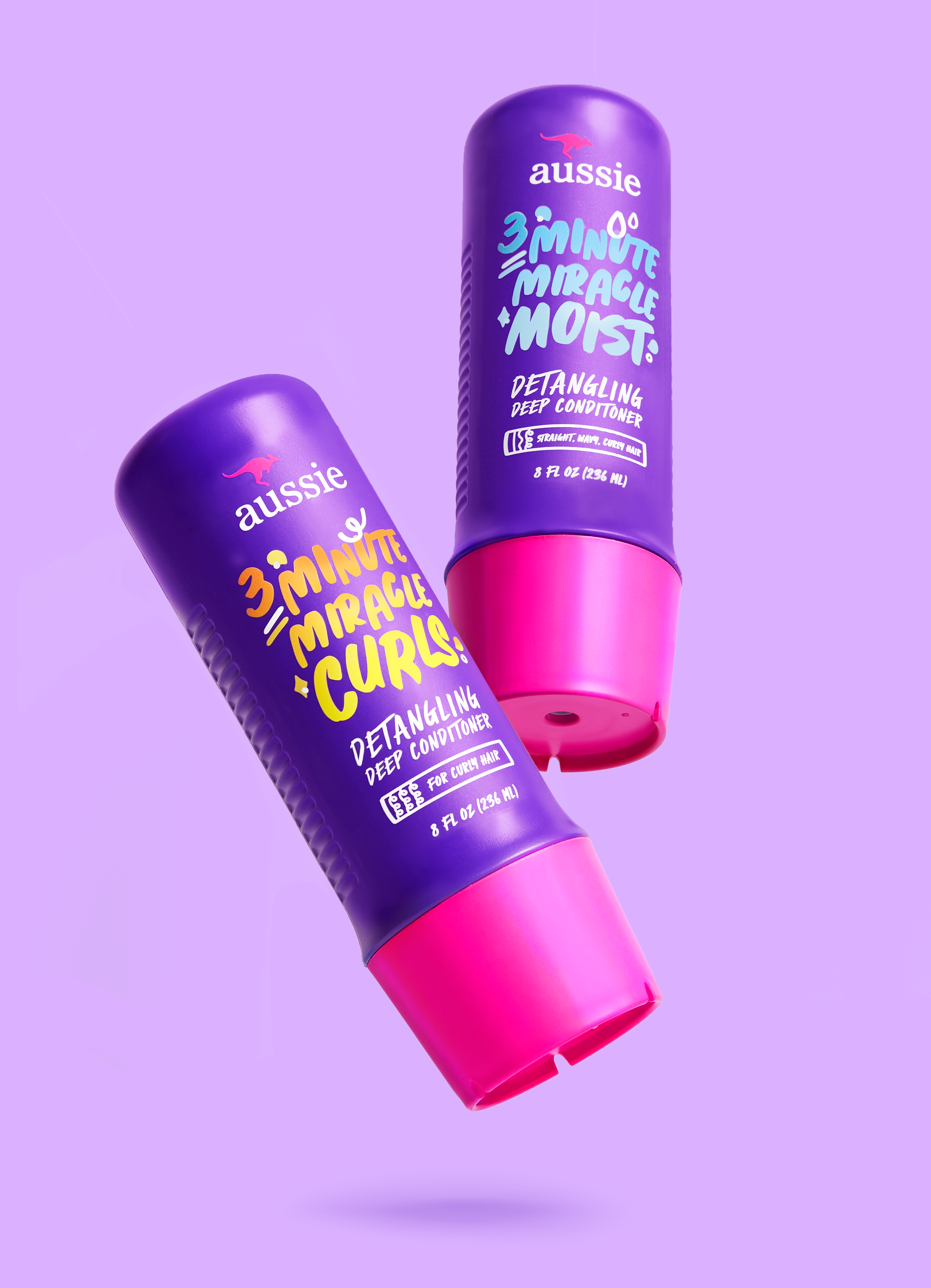 Two purple Aussie 3 Minute Miracle deep conditioners for curly hair with bright pink caps on a lavender background