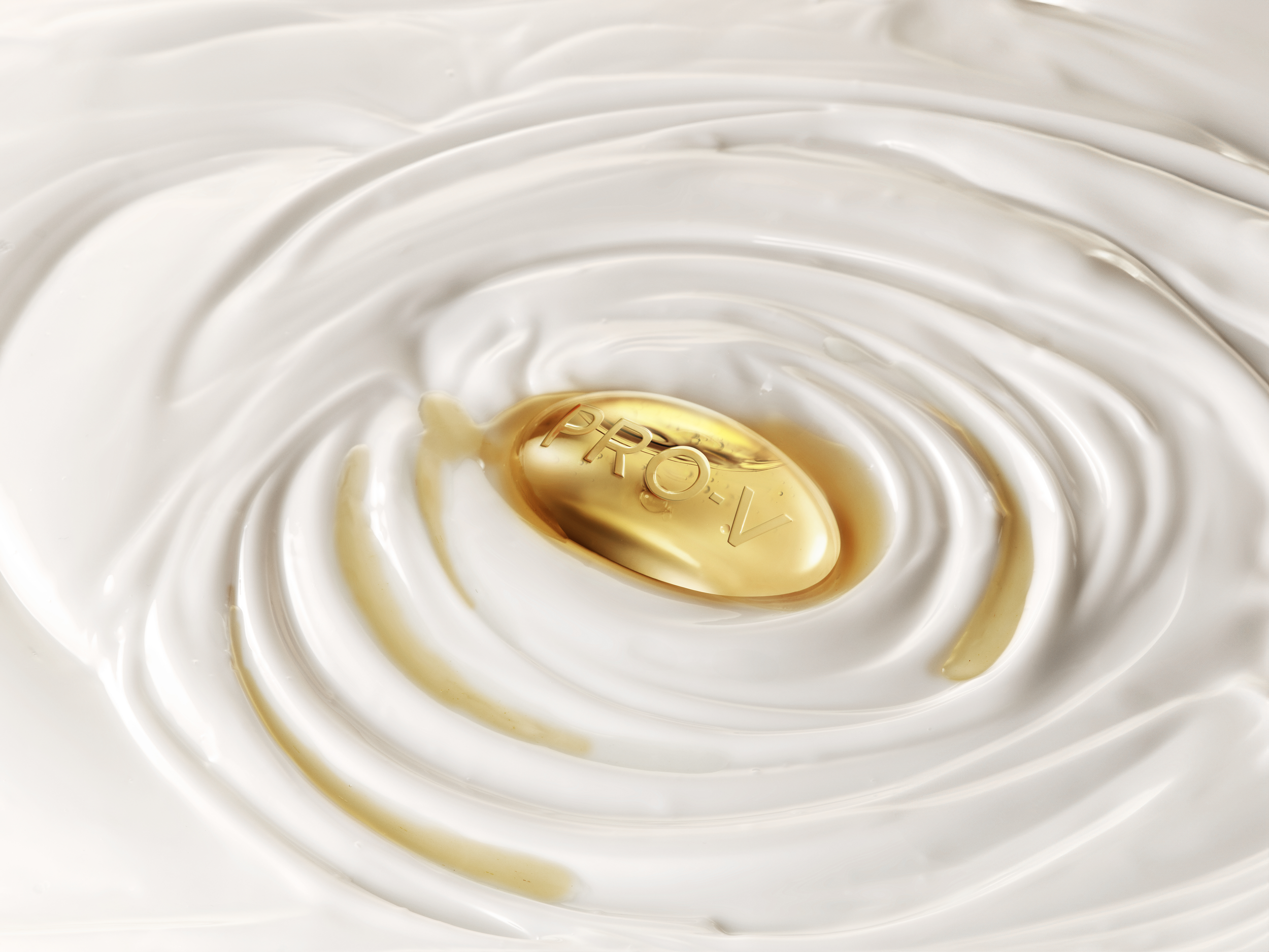 Golden pill labeled “PRO-V” floating in swirling white liquid