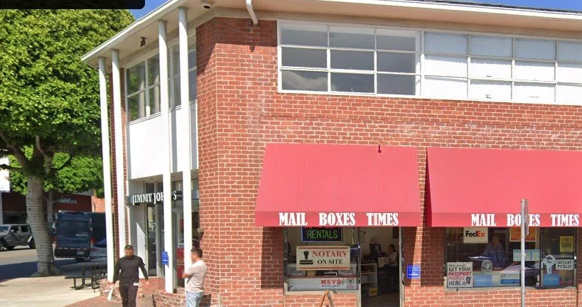 Mail Boxes Times red awnings on a brick building at 9461 Charleville Blvd