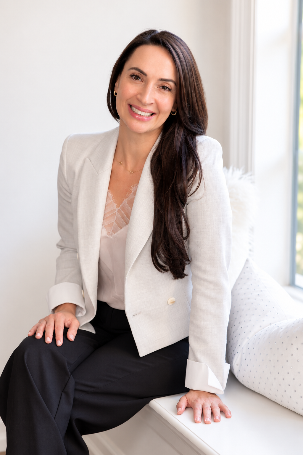Dr. Oksana Gravets seated in a bright clinical office.