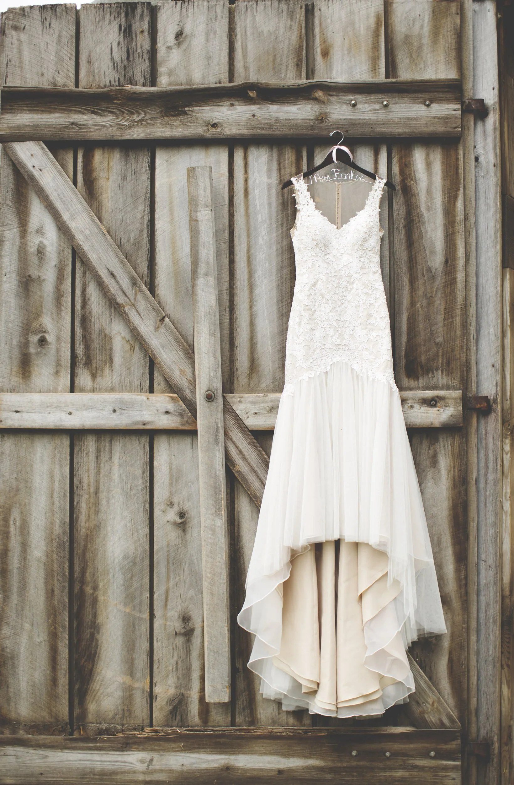 Lace wedding dress hanging on the old barn door