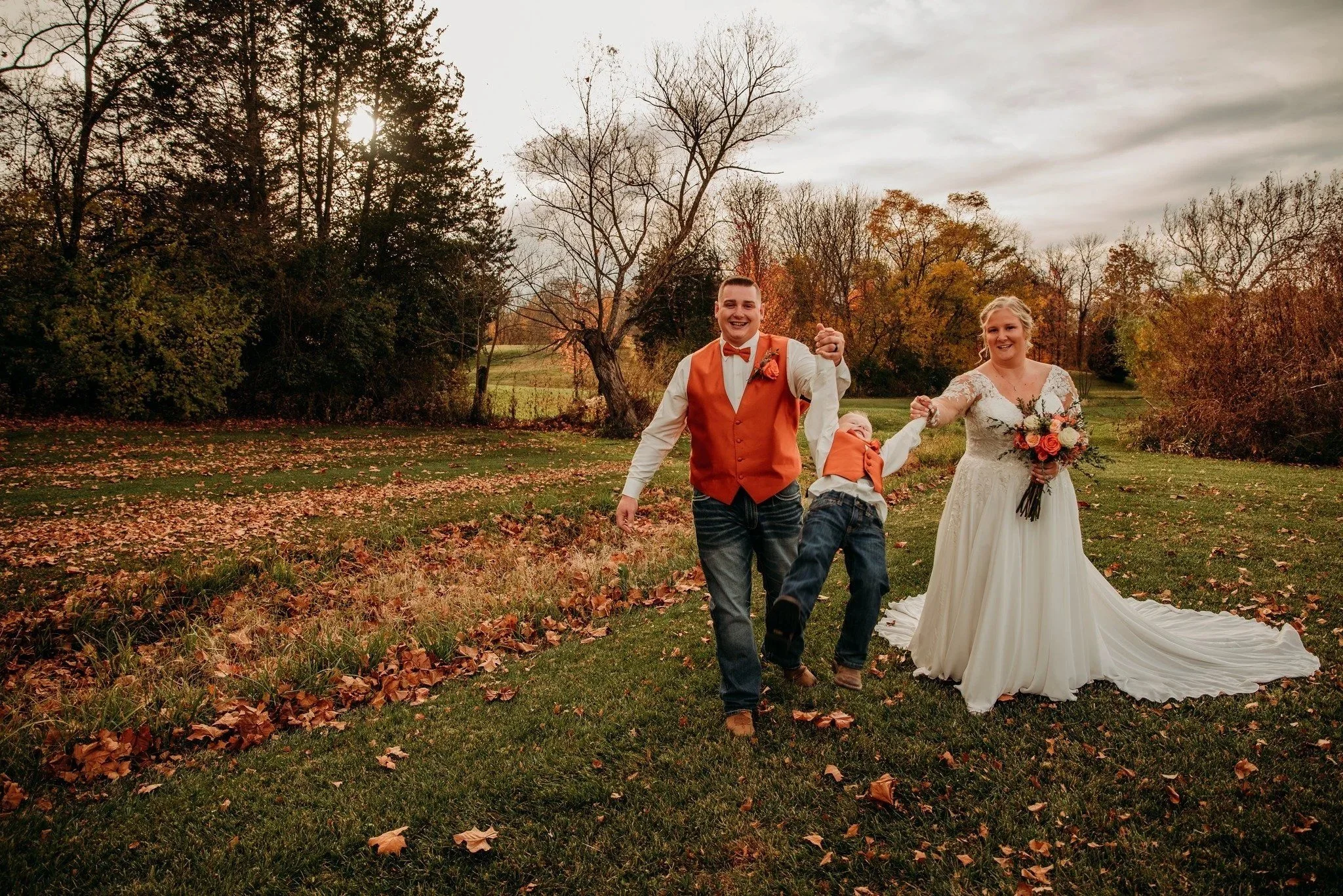 Newlyweds walking across the field with their son