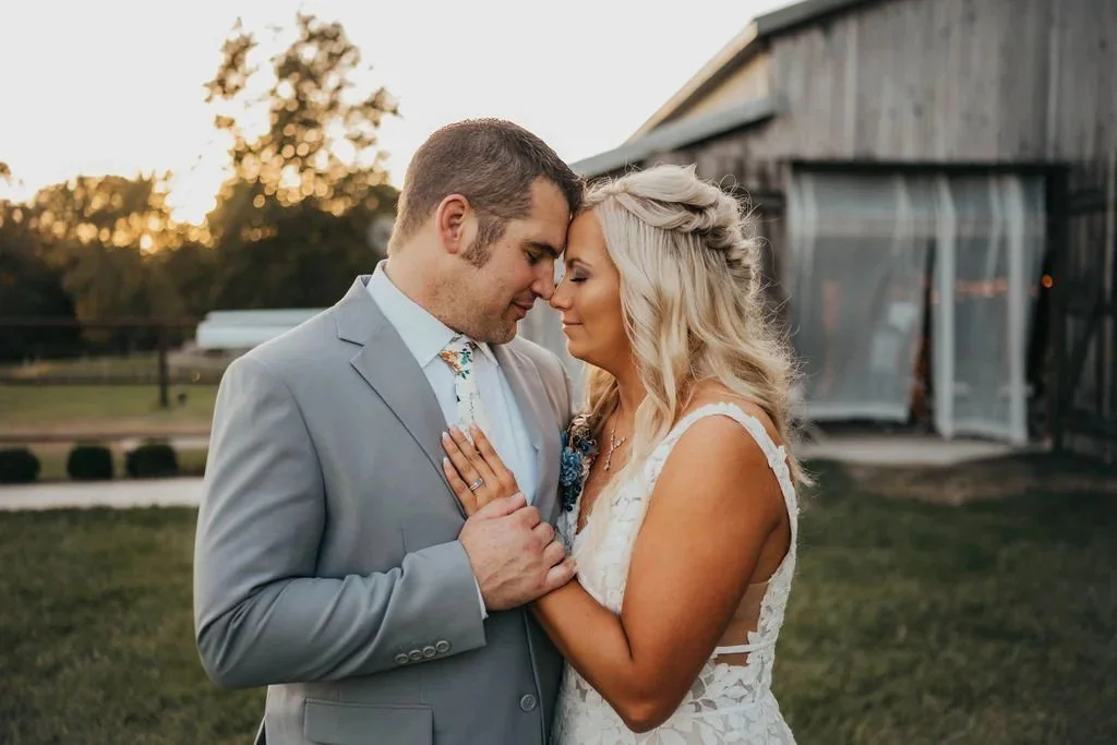 Bride and groom embracing beside the barn