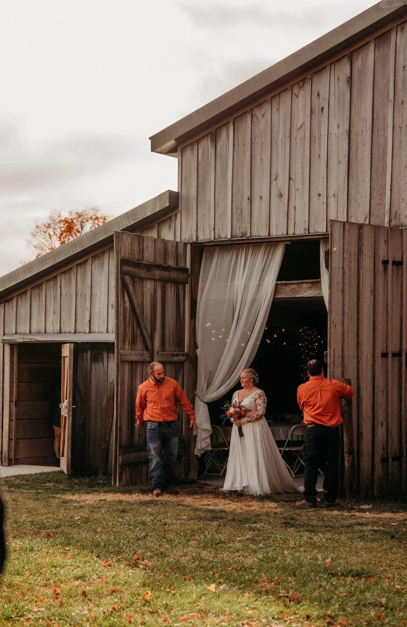 Bride and groomsmen opening the sliding barn doors