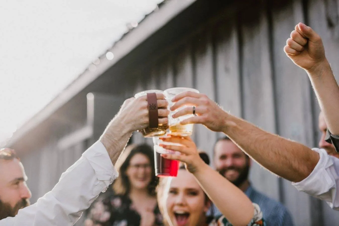 Guests raising drinks in a toast outside the barn