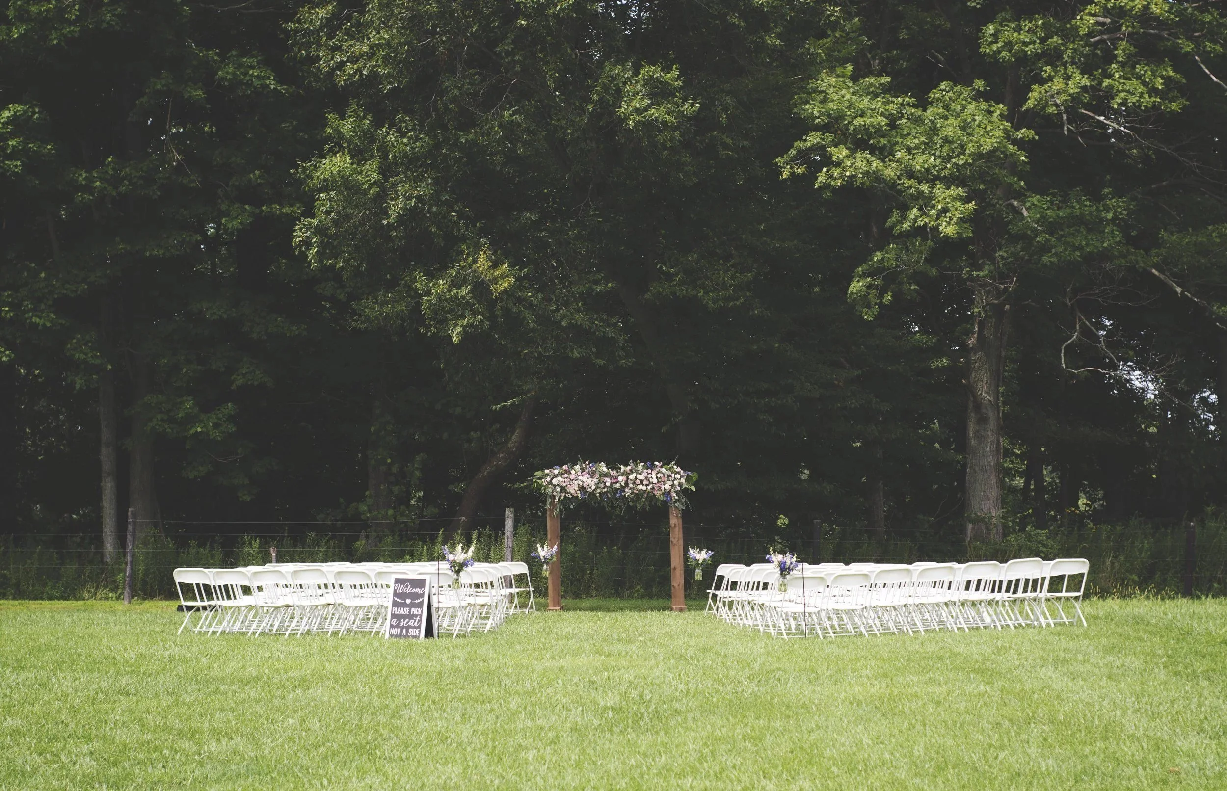 Outdoor ceremony site on the lawn at the edge of the woods